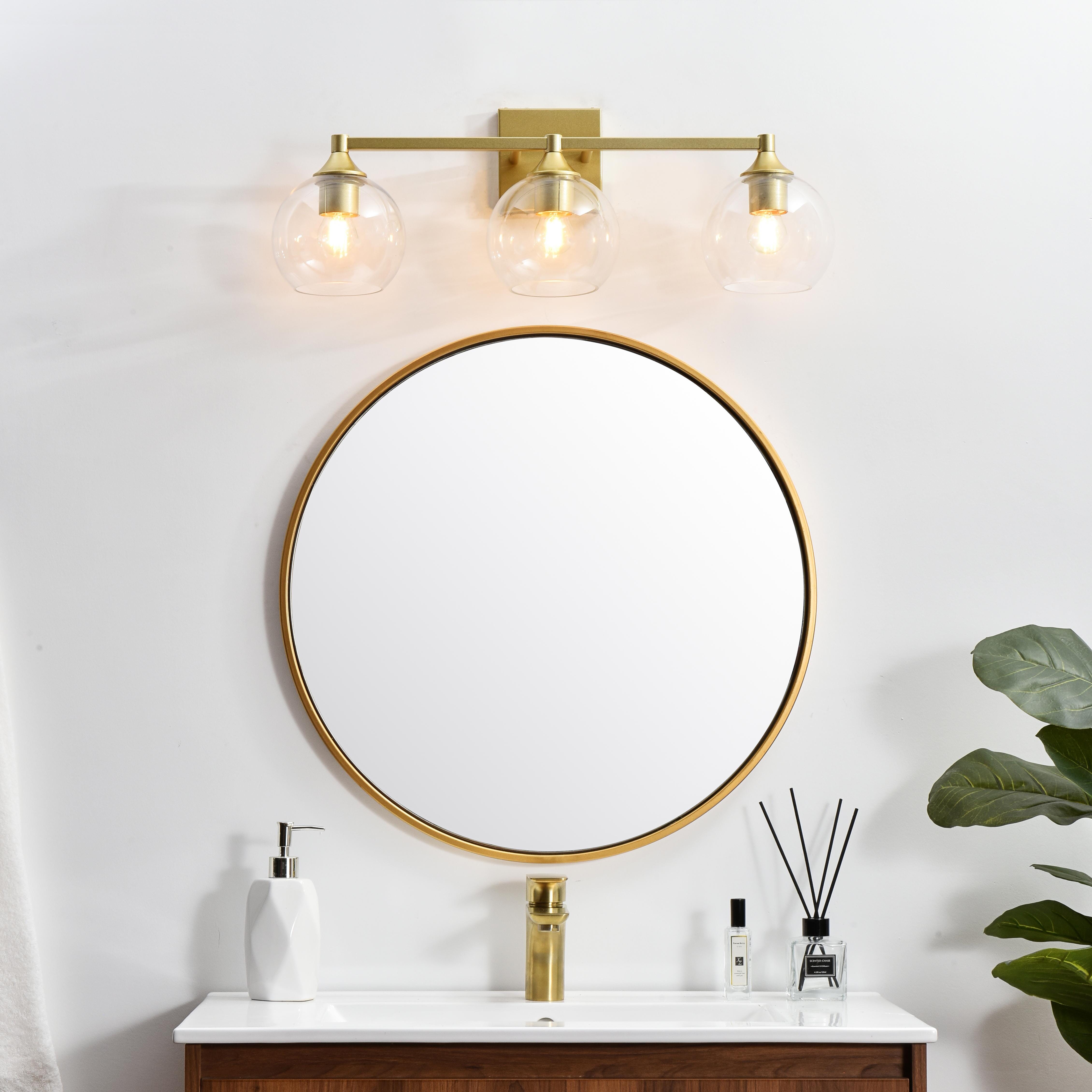 Defined by a sleek metal arm extends to suspend the clear pear-shaped glass shade. A contemporary stunner, it shows off the straight line details from the backplate and the streamline thick metal arm. Compatible with dimmers, so you'll have the right amount of light in any given time of the day. Completely versatile, you can place this wall light as an uplight or downlight. Rated for use in damp locations, this will work perfectly over a vanity in your bathroom. Collection: Foster Rooms: Bathroom Finish: Brass and Clear Glass: Clear Width: 25.00" Height: 9.00" Weight: 4.00 lb Extension from Wall: 8.00" Wire: 8" Black and White Canopy: 4.7"x4.7"x0.8" Number of Bulbs: 3 Maximum Wattage: 40.00 W Bulb Type: E26 Bulb Base: E26 Dimmable Voltage: 110.00 V Material: Iron and Glass Country of Origin: China Safety Listing: ETL Safety Rating: Damp Title 20 Title 24 Manufacturer Warranty: 1 year limited - alternate view
