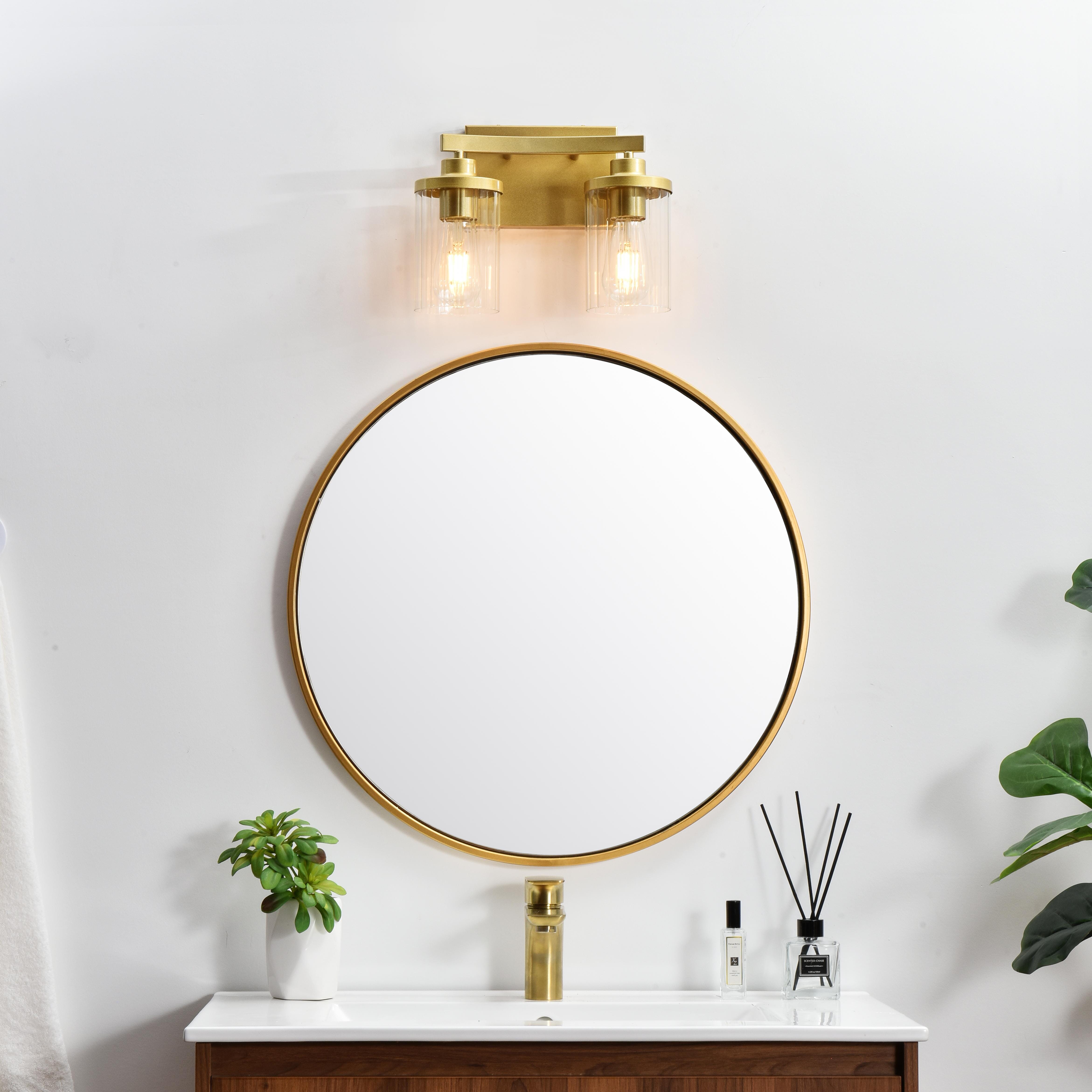 The artful allure of modern sculpture with the function of a light fixture. This glass and metal combination is a perfect example of a modern design. Compatible with dimmers, so you'll have the right amount of light in any given time of the day. Available in multiple finishes. Completely versatile, you can place this wall light as an uplight or downlight. Collection: Saanvi Rooms: Bathroom Finish: Brass and Clear Glass: Clear Width: 12.00" Height: 10.00" Weight: 3.00 lb Extension from Wall: 6.00" Wire: 8" Black and White Canopy: 7.1"x4.7"x0.8" Number of Bulbs: 2 Maximum Wattage: 40.00 W Bulb Type: E26 Bulb Base: E26 Dimmable Voltage: 110.00 V Material: Iron and Glass Country of Origin: China Safety Listing: ETL Safety Rating: Damp Title 20 Title 24 Manufacturer Warranty: 1 year limited - alternate view