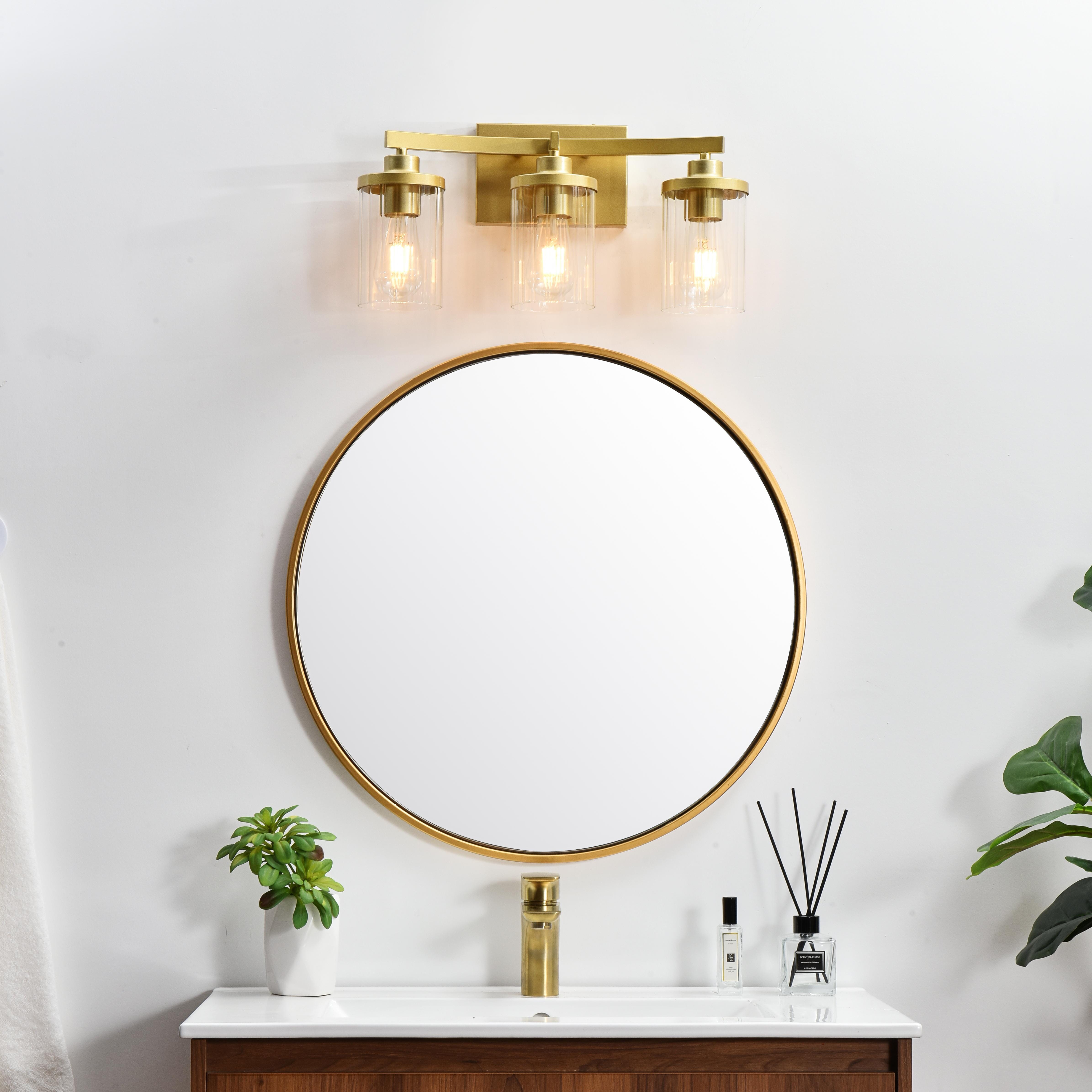 The artful allure of modern sculpture with the function of a light fixture. This glass and metal combination is a perfect example of a modern design. Compatible with dimmers, so you'll have the right amount of light in any given time of the day. Available in multiple finishes. Completely versatile, you can place this wall light as an uplight or downlight. Collection: Saanvi Rooms: Bathroom Finish: Brass and Clear Glass: Clear Width: 18.00" Height: 10.00" Weight: 4.00 lb Extension from Wall: 6.00" Wire: 8" Black and White Canopy: 7.1"x4.7"x0.8" Number of Bulbs: 3 Maximum Wattage: 40.00 W Bulb Type: E26 Bulb Base: E26 Dimmable Voltage: 110.00 V Material: Iron and Glass Country of Origin: China Safety Listing: ETL Safety Rating: Damp Title 20 Title 24 Manufacturer Warranty: 1 year limited - alternate view