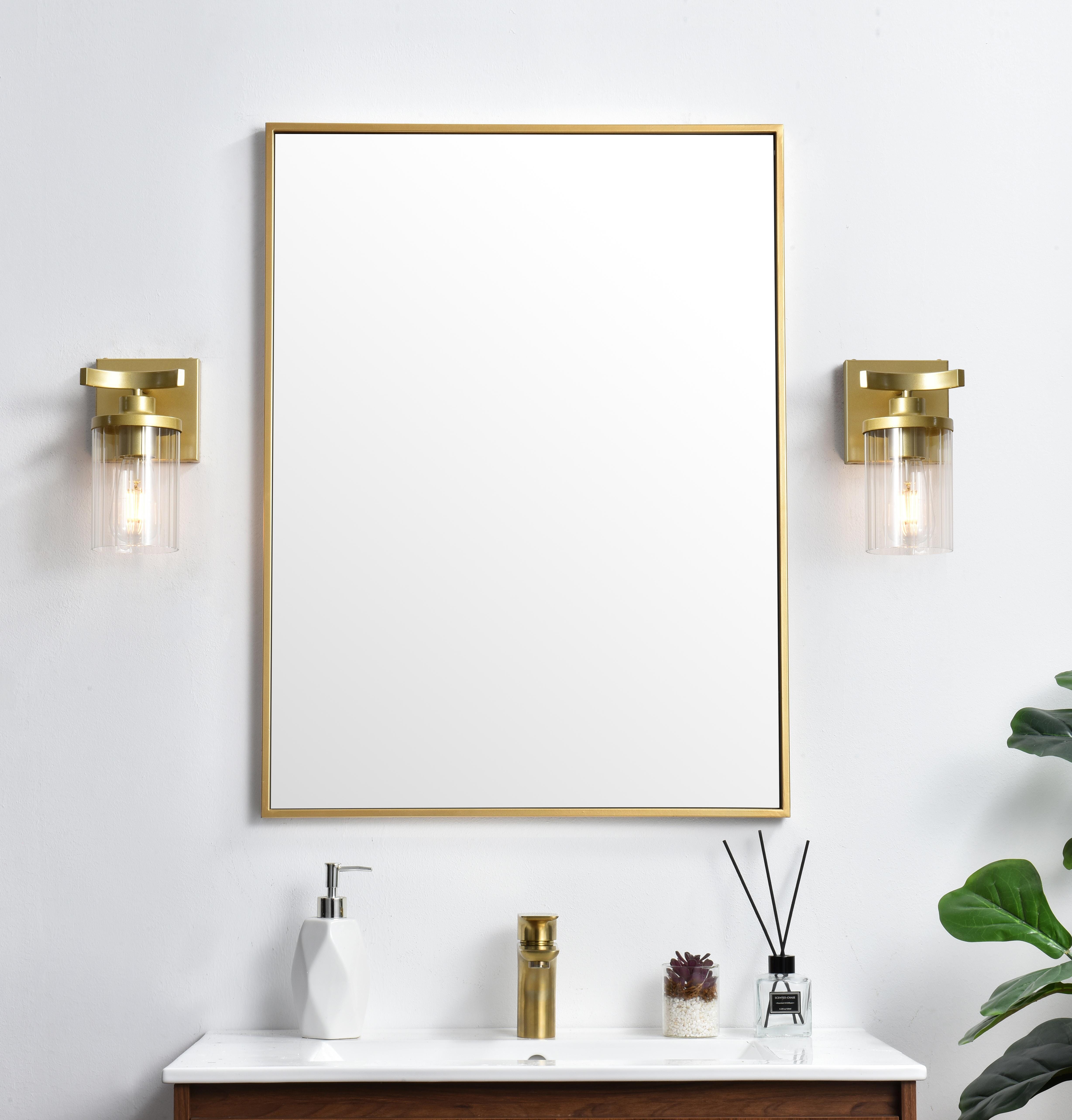 The artful allure of modern sculpture with the function of a light fixture. This glass and metal combination is a perfect example of a modern design. Compatible with dimmers, so you'll have the right amount of light in any given time of the day. Available in multiple finishes. Completely versatile, you can place this wall light as an uplight or downlight. Collection: Saanvi Rooms: Bathroom Finish: Brass and Clear Glass: Clear Width: 5.00" Height: 10.00" Weight: 2.00 lb Extension from Wall: 6.00" Wire: 8" Black and White Canopy: 4.7"x4.7"x0.8" Number of Bulbs: 1 Maximum Wattage: 40.00 W Bulb Type: E26 Bulb Base: E26 Dimmable Voltage: 110.00 V Material: Iron and Glass Country of Origin: China Safety Listing: ETL Safety Rating: Damp Title 20 Title 24 Manufacturer Warranty: 1 year limited - alternate view