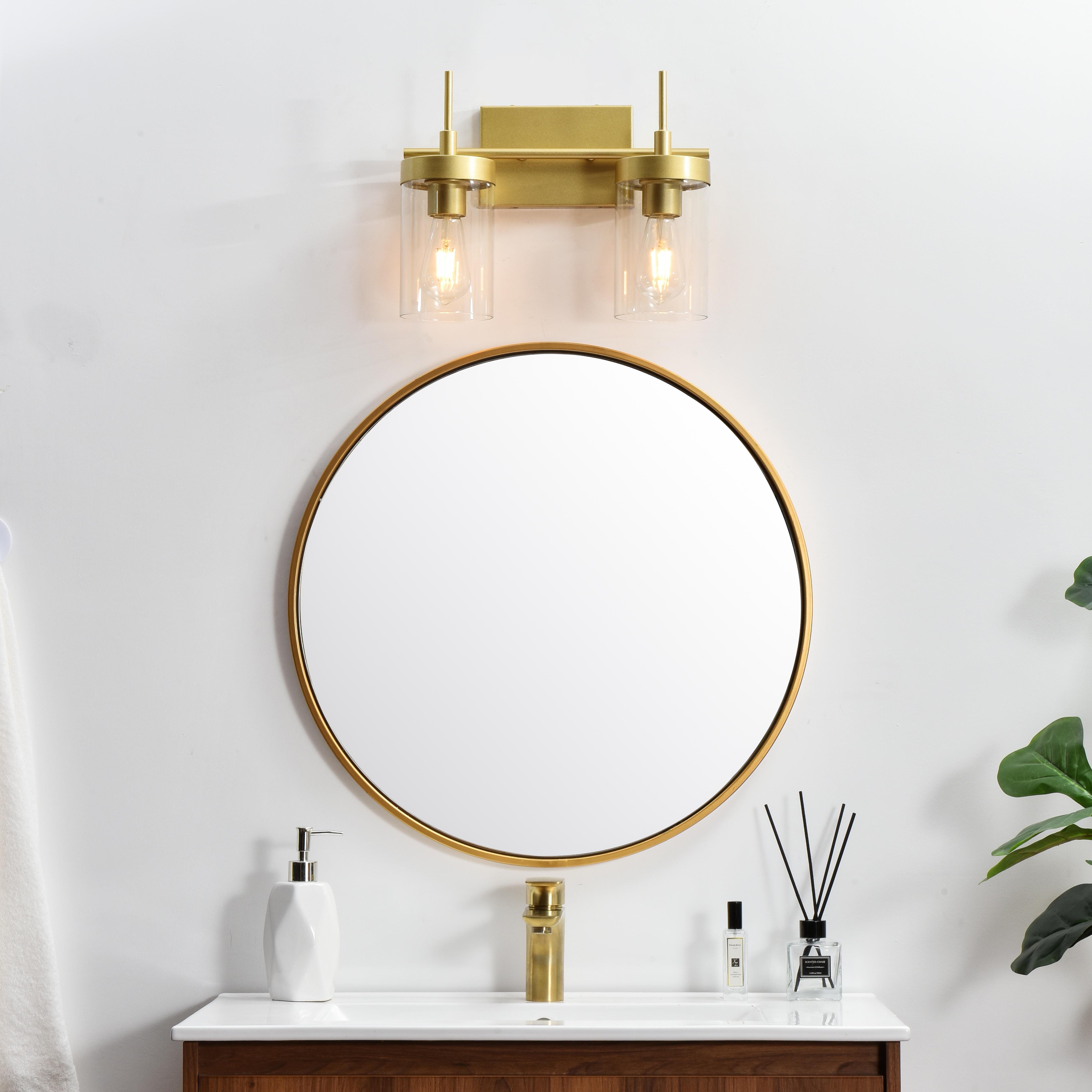 Defined by curved metal arm extends to suspend the clear bell glass shade. A contemporary stunner, it shows off the straight line details from the backplate and the streamline thin metal arm. Compatible with dimmers, so you'll have the right amount of light in any given time of the day. Completely versatile, you can place this wall light as an uplight or downlight. Rated for use in damp locations, this will work perfectly over a vanity in your bathroom. Collection: Benny Rooms: Bathroom Finish: Brass and Clear Glass: Clear Width: 14.00" Height: 11.00" Weight: 4.00 lb Extension from Wall: 6.00" Wire: 8" Black and White Canopy: 7.1"x4.7"x0.8" Number of Bulbs: 2 Maximum Wattage: 40.00 W Bulb Type: E26 Bulb Base: E26 Dimmable Voltage: 110.00 V Material: Iron and Glass Country of Origin: China Safety Listing: ETL Safety Rating: Damp Title 20 Title 24 Manufacturer Warranty: 1 year limited - alternate view