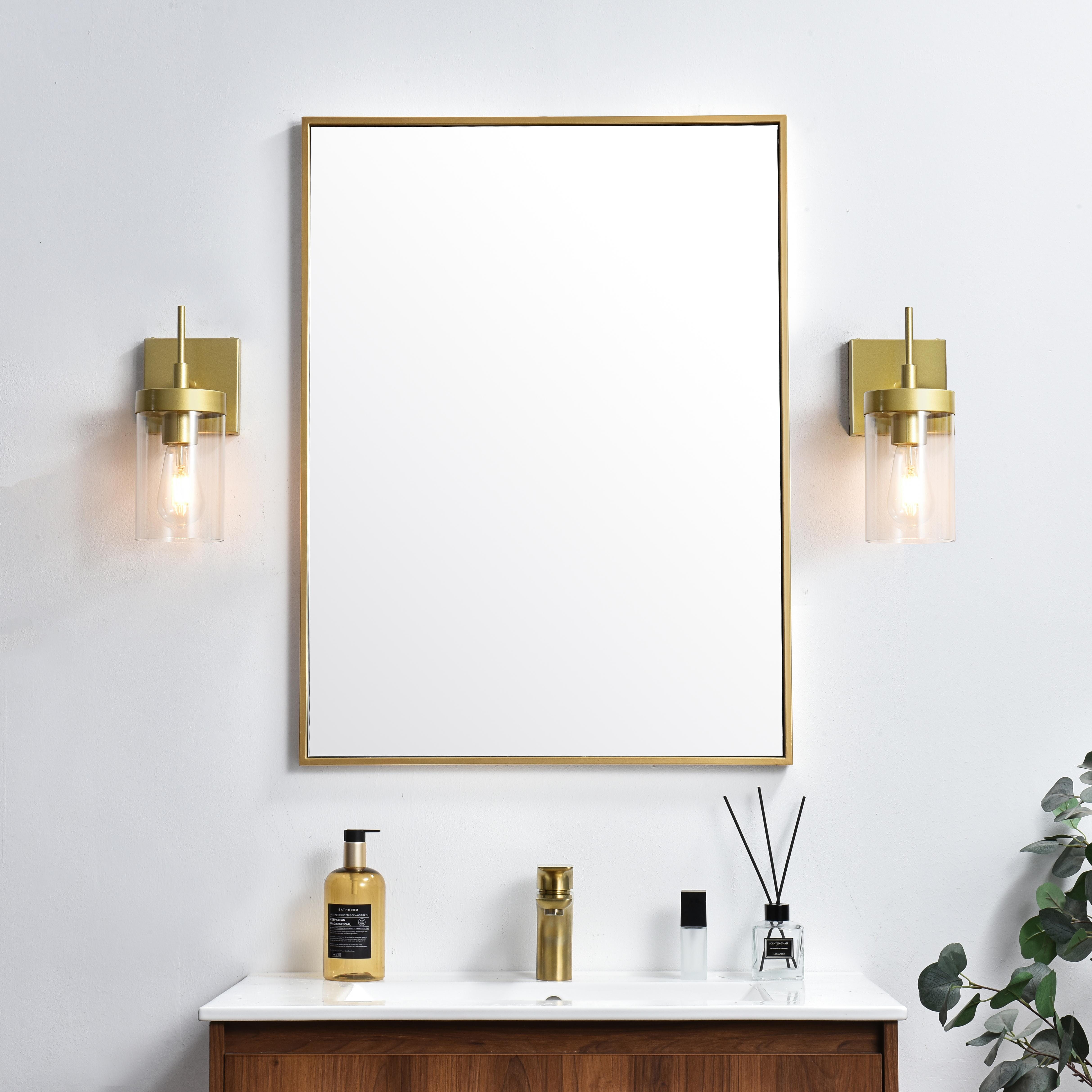 Defined by curved metal arm extends to suspend the clear bell glass shade. A contemporary stunner, it shows off the straight line details from the backplate and the streamline thin metal arm. Compatible with dimmers, so you'll have the right amount of light in any given time of the day. Completely versatile, you can place this wall light as an uplight or downlight. Rated for use in damp locations, this will work perfectly over a vanity in your bathroom. Collection: Benny Rooms: Bathroom Finish: Brass and Clear Glass: Clear Width: 5.00" Height: 11.00" Weight: 2.00 lb Extension from Wall: 6.00" Wire: 8" Black and White Canopy: 4.7"x4.7"x0.8" Number of Bulbs: 1 Maximum Wattage: 40.00 W Bulb Type: E26 Bulb Base: E26 Dimmable Voltage: 110.00 V Material: Iron and Glass Country of Origin: China Safety Listing: ETL Safety Rating: Damp Title 20 Title 24 Manufacturer Warranty: 1 year limited - alternate view