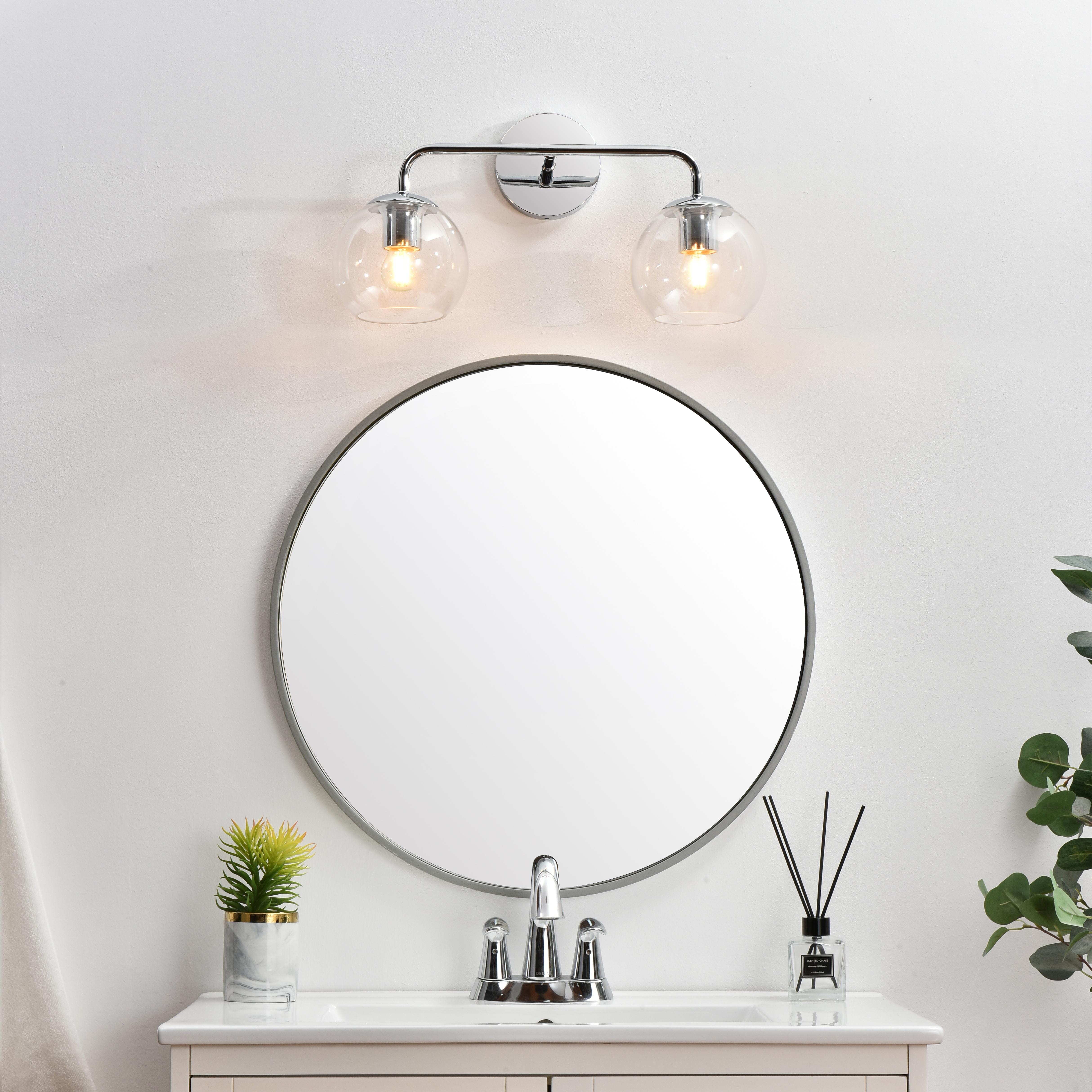A modern twist on a traditional design, this vanity light is perfect for sprucing up your bathroom. Rated for use in damp locations, this iron fixture features a round backplate, curved arms, and orb accents. Completely versatile, you can place this wall light as an uplight or downlight. Rated for use in damp locations, this will work perfectly over a vanity in your bathroom. Collection: Genesis Rooms: Bathroom Finish: Chrome and Clear Glass: Clear Width: 19.00" Height: 10.00" Weight: 2.00 lb Extension from Wall: 8.00" Wire: 8" Black and White Canopy: 4.7"x1"x4.7" Number of Bulbs: 2 Maximum Wattage: 40.00 W Bulb Type: E26 Bulb Base: E26 Dimmable Voltage: 110.00 V Material: Iron and Glass Country of Origin: China Safety Listing: ETL Safety Rating: Damp Title 20 Title 24 Manufacturer Warranty: 1 year limited - alternate view