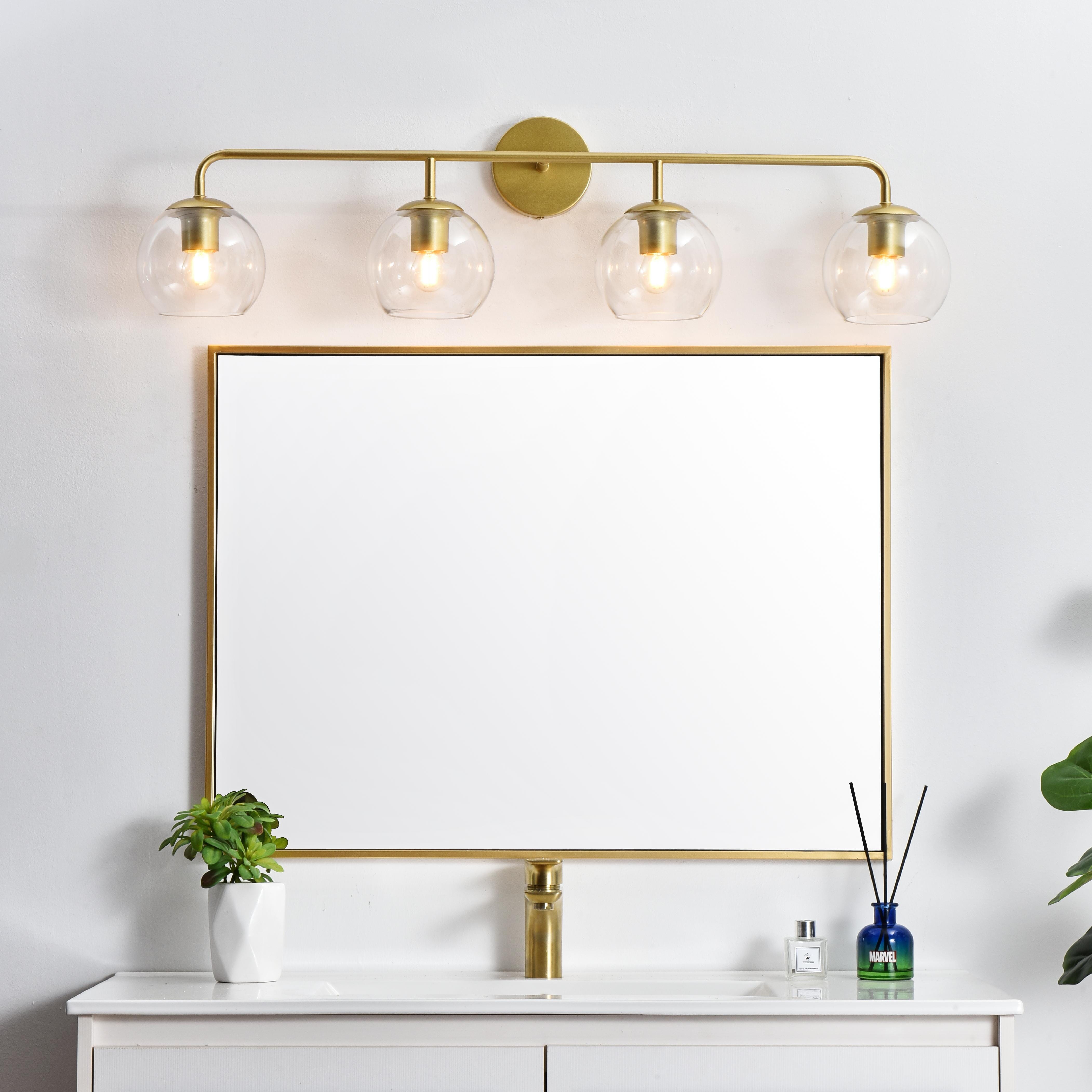 A modern twist on a traditional design, this vanity light is perfect for sprucing up your bathroom. Rated for use in damp locations, this iron fixture features a round backplate, curved arms, and orb accents. Completely versatile, you can place this wall light as an uplight or downlight. Rated for use in damp locations, this will work perfectly over a vanity in your bathroom. Collection: Genesis Rooms: Bathroom Finish: Brass and Clear Glass: Clear Width: 37.00" Height: 10.00" Weight: 4.00 lb Extension from Wall: 8.00" Wire: 8" Black and White Canopy: 4.7"x1"x4.7" Number of Bulbs: 4 Maximum Wattage: 40.00 W Bulb Type: E26 Bulb Base: E26 Dimmable Voltage: 110.00 V Material: Iron and Glass Country of Origin: China Safety Listing: ETL Safety Rating: Damp Title 20 Title 24 Manufacturer Warranty: 1 year limited - alternate view