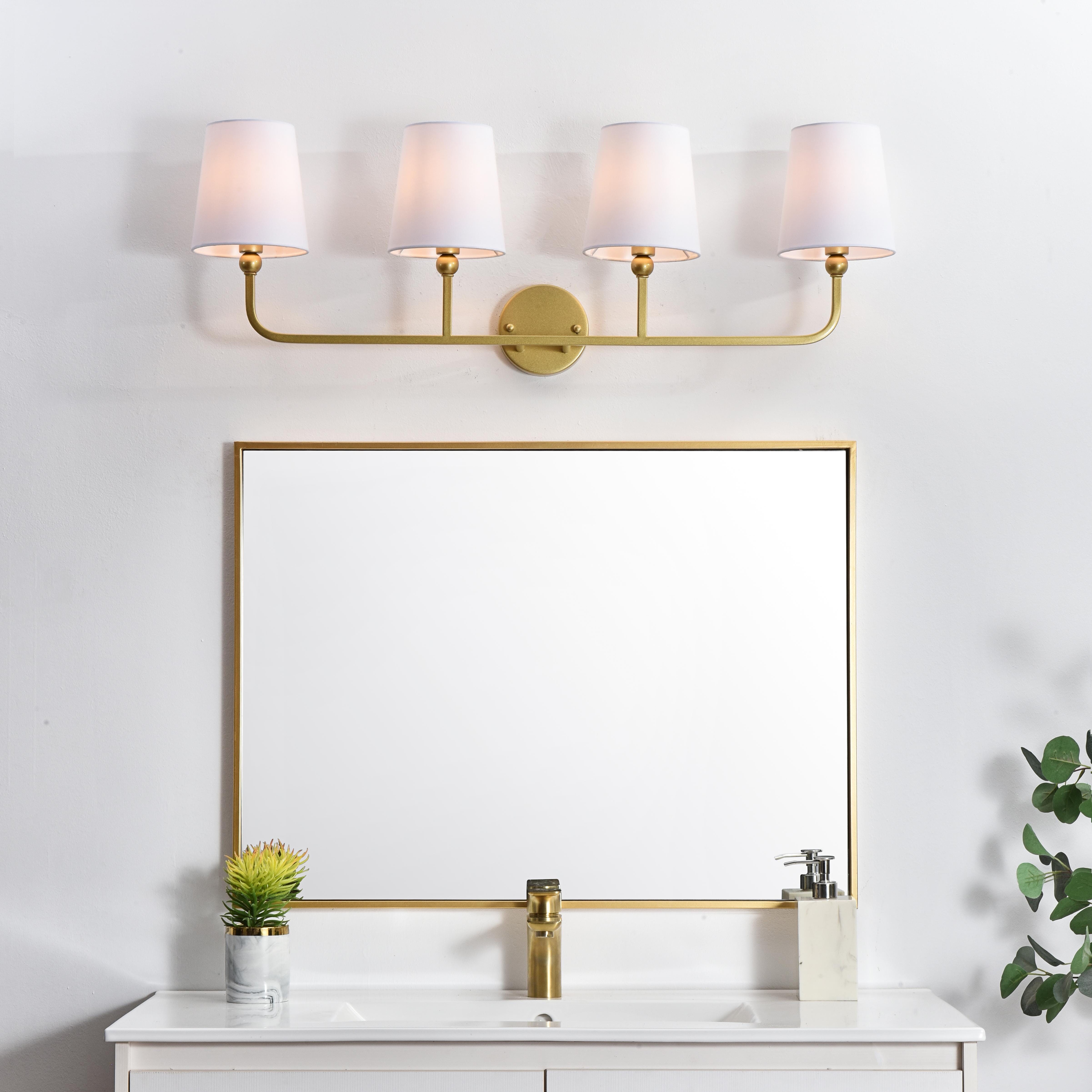 A modern twist on a traditional design, this vanity light is perfect for sprucing up your bathroom. Rated for use in damp locations, this iron fixture features a round backplate, curved arms, and fabric shade accents. Completely versatile, you can place this wall light as an uplight or downlight. Rated for use in damp locations, this will work perfectly over a vanity in your bathroom. Collection: Colson Rooms: Bathroom Finish: Brass and Clear Glass: White Width: 36.00" Height: 12.00" Weight: 3.00 lb Extension from Wall: 7.50" Wire: 8" Black and White Canopy: 4.7"x1"x4.7" Number of Bulbs: 4 Maximum Wattage: 40.00 W Bulb Type: E12 Bulb Base: E12 Dimmable Voltage: 110.00 V Material: Metal and Fabric shade Country of Origin: China Safety Listing: ETL Safety Rating: Damp Title 20 Title 24 Manufacturer Warranty: 1 year limited - alternate view