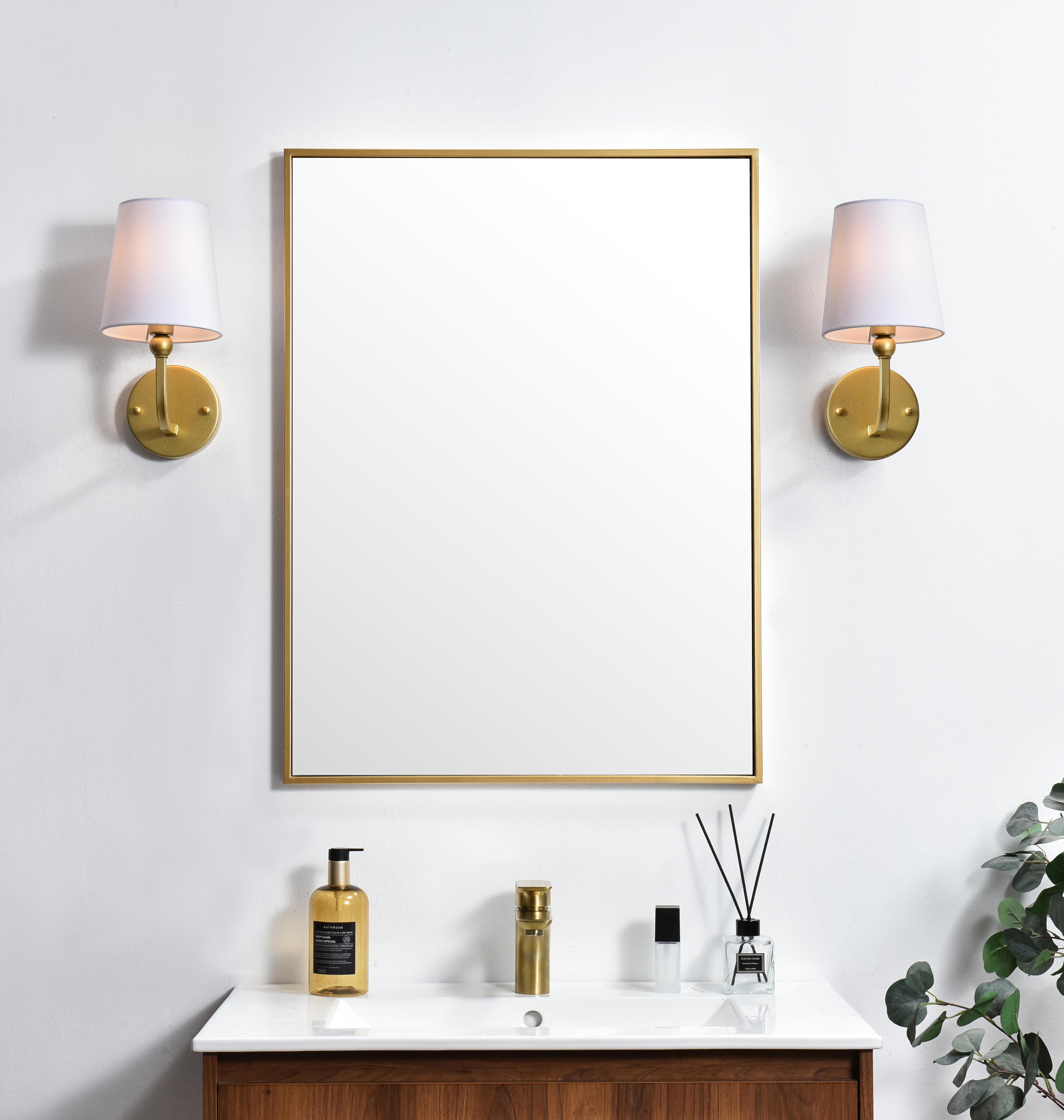 A modern twist on a traditional design, this vanity light is perfect for sprucing up your bathroom. Rated for use in damp locations, this iron fixture features a round backplate, curved arms, and fabric shade accents. Completely versatile, you can place this wall light as an uplight or downlight. Rated for use in damp locations, this will work perfectly over a vanity in your bathroom. Collection: Colson Rooms: Bathroom Finish: Brass and Clear Glass: White Width: 6.00" Height: 12.00" Weight: 1.00 lb Extension from Wall: 7.50" Wire: 8" Black and White Canopy: 4.7"x1"x4.7" Number of Bulbs: 1 Maximum Wattage: 40.00 W Bulb Type: E12 Bulb Base: E12 Dimmable Voltage: 110.00 V Material: Metal and Fabric shade Country of Origin: China Safety Listing: ETL Safety Rating: Damp Title 20 Title 24 Manufacturer Warranty: 1 year limited - alternate view