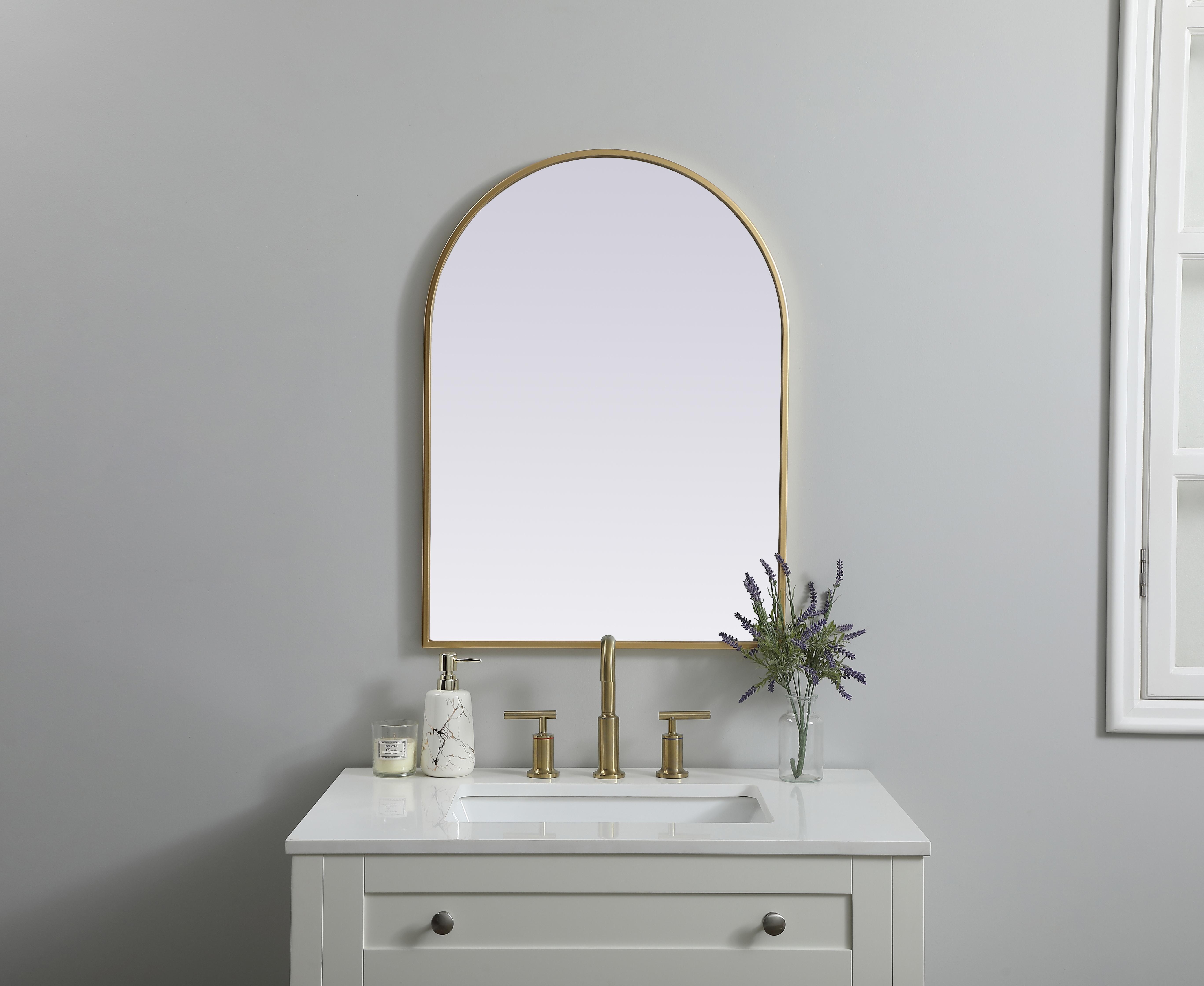 Instantly open up any space in your home with this minimalist wall-mounted mirror. Crafted of metal, this mirror strikes a round silhouette. Its slender, clean-lined frame sports a classic finish, while the glass mirror within features a flat, for a brilliant reflection, letting the light bounce off to expand your space. Designed in an arch shape, this metal-frame mirror showcases in the three available satin finishes in black, brass, or silver. Mount this work of art in any room of your choice for added visual impact. Collection: Ayra Finish: Brass Width: 22.00" Height: 30.00" Length: 30.00" Weight: 12.00 lb Material: iron and MDF Country of Origin: China Manufacturer Warranty: 1 year limited - alternate view