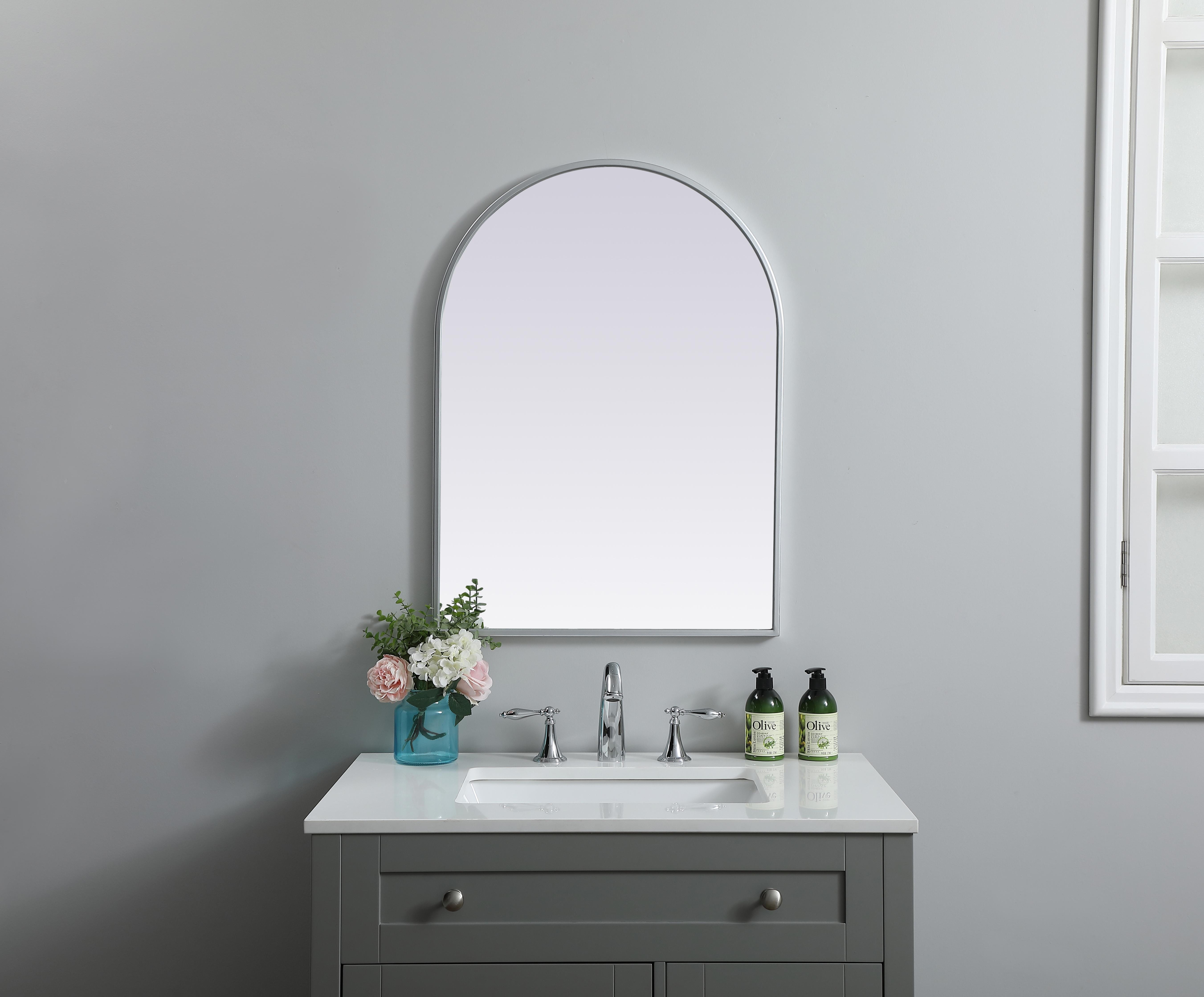 Instantly open up any space in your home with this minimalist wall-mounted mirror. Crafted of metal, this mirror strikes a round silhouette. Its slender, clean-lined frame sports a classic finish, while the glass mirror within features a flat, for a brilliant reflection, letting the light bounce off to expand your space. Designed in an arch shape, this metal-frame mirror showcases in the three available satin finishes in black, brass, or silver. Mount this work of art in any room of your choice for added visual impact. Collection: Ayra Finish: Silver Width: 22.00" Height: 30.00" Length: 30.00" Weight: 12.00 lb Material: iron and MDF Country of Origin: China Manufacturer Warranty: 1 year limited - alternate view