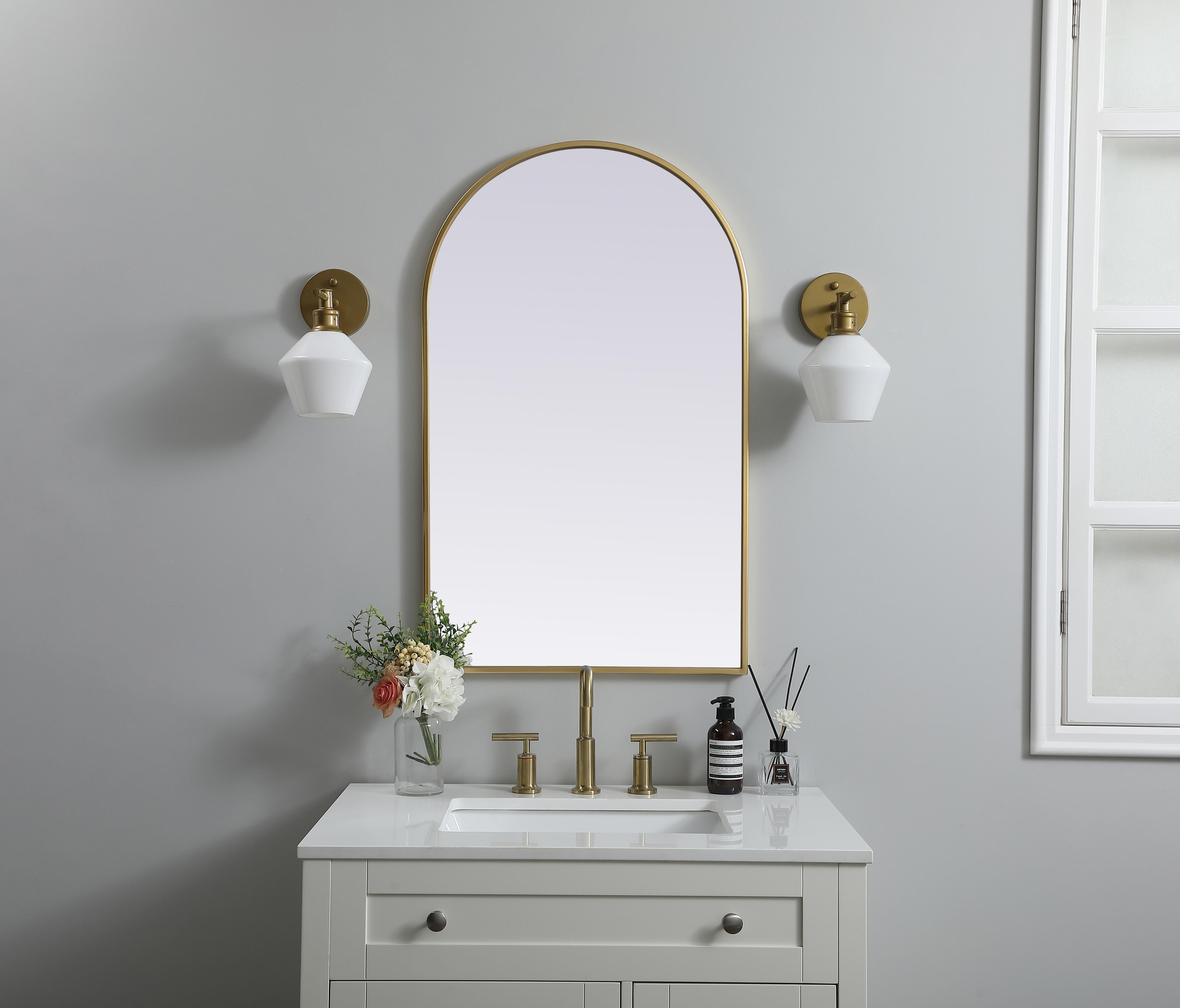 Instantly open up any space in your home with this minimalist wall-mounted mirror. Crafted of metal, this mirror strikes a round silhouette. Its slender, clean-lined frame sports a classic finish, while the glass mirror within features a flat, for a brilliant reflection, letting the light bounce off to expand your space. Designed in an arch shape, this metal-frame mirror showcases in the three available satin finishes in black, brass, or silver. Mount this work of art in any room of your choice for added visual impact. Collection: Ayra Finish: Brass Width: 22.00" Height: 36.00" Length: 36.00" Weight: 15.00 lb Material: iron and MDF Country of Origin: China Manufacturer Warranty: 1 year limited - alternate view