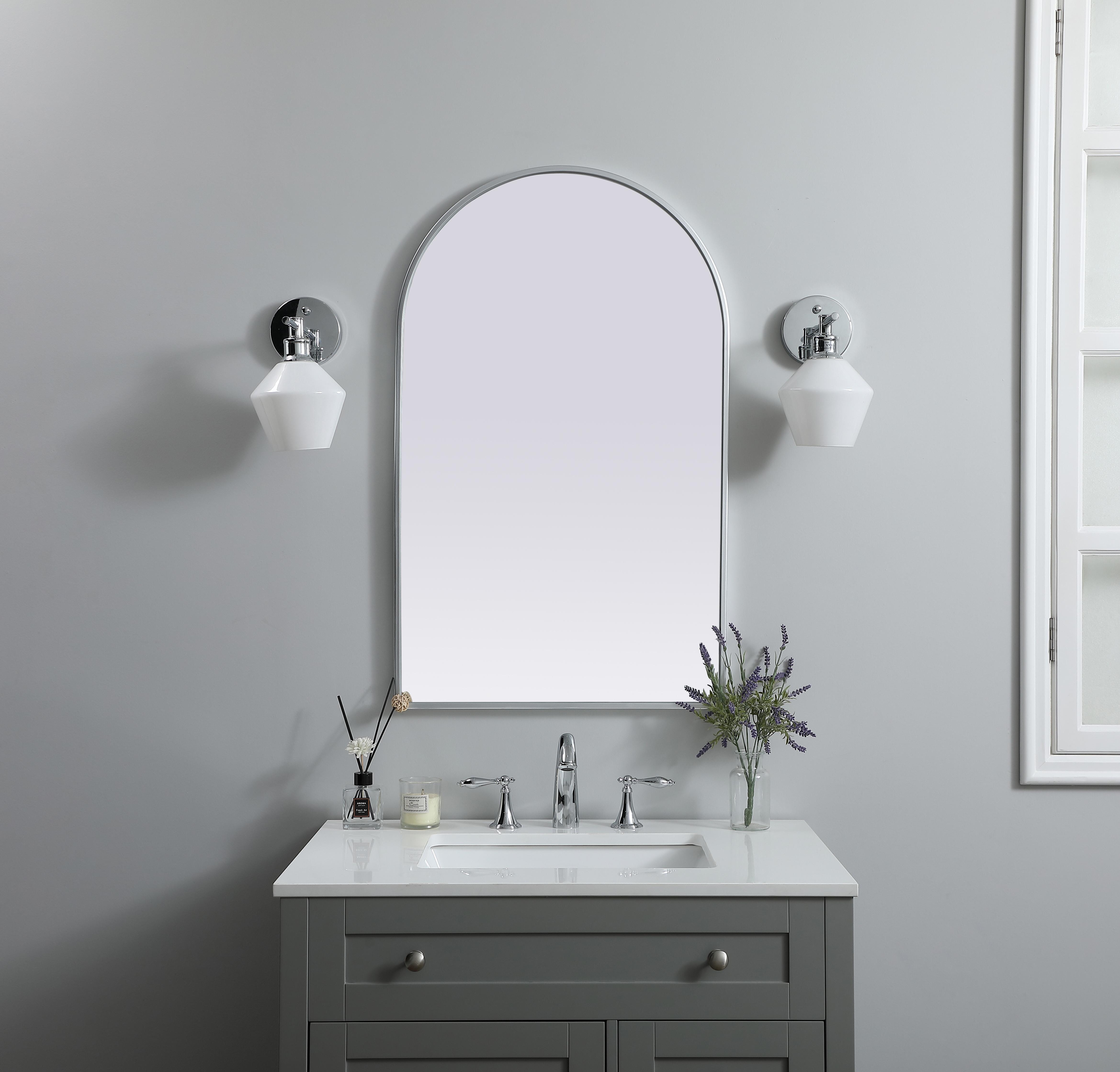 Instantly open up any space in your home with this minimalist wall-mounted mirror. Crafted of metal, this mirror strikes a round silhouette. Its slender, clean-lined frame sports a classic finish, while the glass mirror within features a flat, for a brilliant reflection, letting the light bounce off to expand your space. Designed in an arch shape, this metal-frame mirror showcases in the three available satin finishes in black, brass, or silver. Mount this work of art in any room of your choice for added visual impact. Collection: Ayra Finish: Silver Width: 22.00" Height: 36.00" Length: 36.00" Weight: 15.00 lb Material: iron and MDF Country of Origin: China Manufacturer Warranty: 1 year limited - alternate view