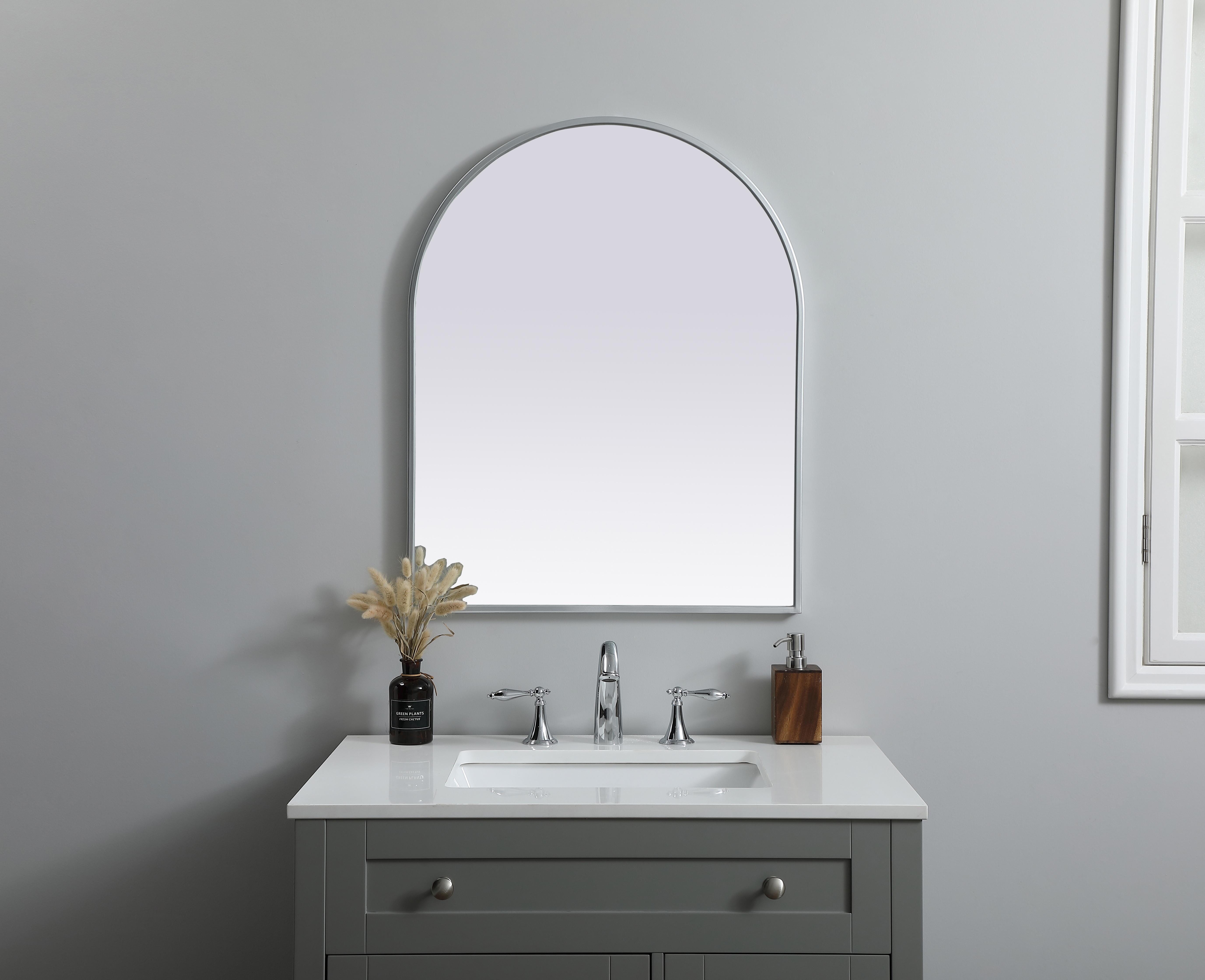 Instantly open up any space in your home with this minimalist wall-mounted mirror. Crafted of metal, this mirror strikes a round silhouette. Its slender, clean-lined frame sports a classic finish, while the glass mirror within features a flat, for a brilliant reflection, letting the light bounce off to expand your space. Designed in an arch shape, this metal-frame mirror showcases in the three available satin finishes in black, brass, or silver. Mount this work of art in any room of your choice for added visual impact. Collection: Ayra Finish: Silver Width: 24.00" Height: 30.00" Length: 30.00" Weight: 13.00 lb Material: iron and MDF Country of Origin: China Manufacturer Warranty: 1 year limited - alternate view