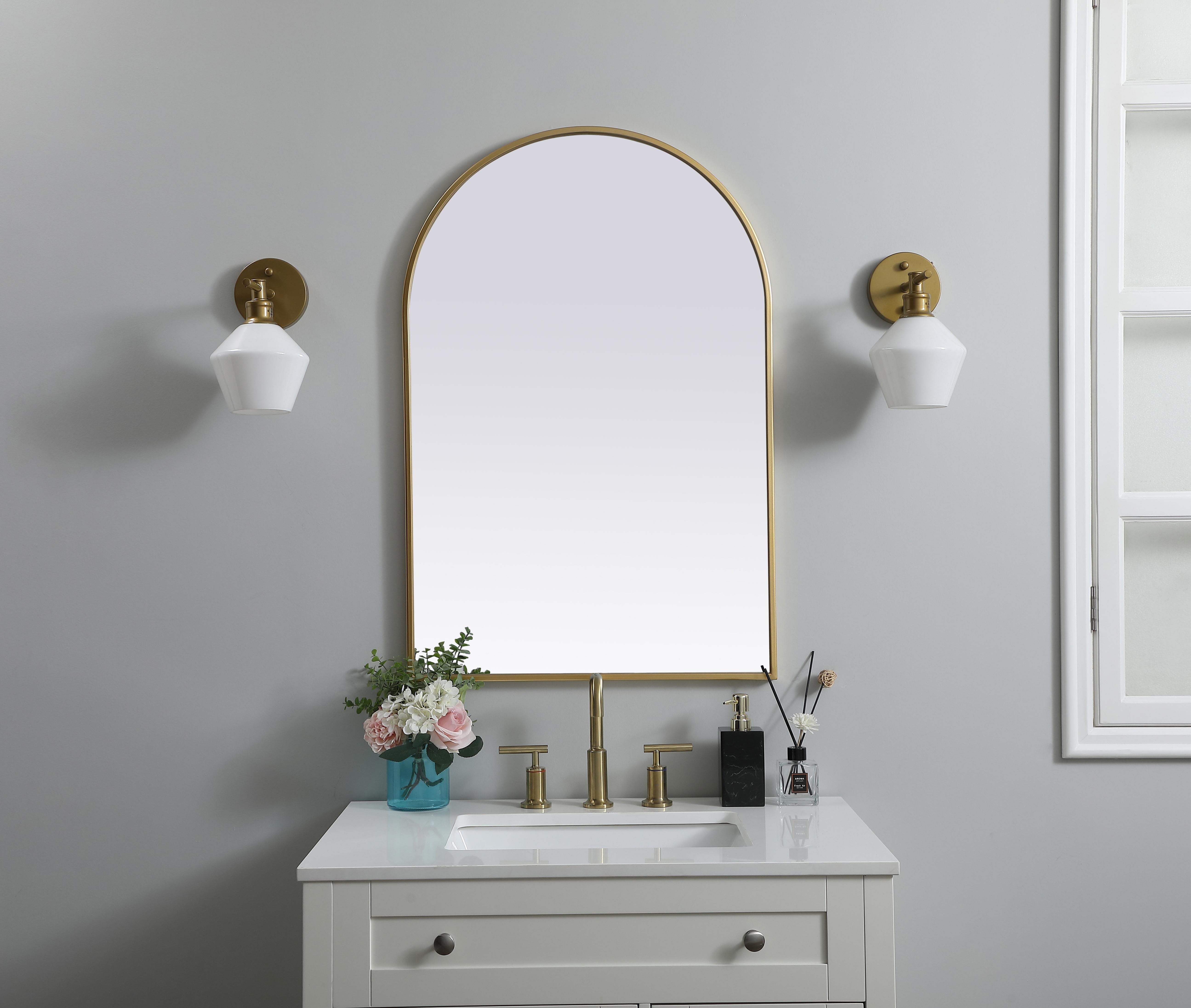 Instantly open up any space in your home with this minimalist wall-mounted mirror. Crafted of metal, this mirror strikes a round silhouette. Its slender, clean-lined frame sports a classic finish, while the glass mirror within features a flat, for a brilliant reflection, letting the light bounce off to expand your space. Designed in an arch shape, this metal-frame mirror showcases in the three available satin finishes in black, brass, or silver. Mount this work of art in any room of your choice for added visual impact. Collection: Ayra Finish: Brass Width: 24.00" Height: 36.00" Length: 36.00" Weight: 16.00 lb Material: iron and MDF Country of Origin: China Manufacturer Warranty: 1 year limited - alternate view