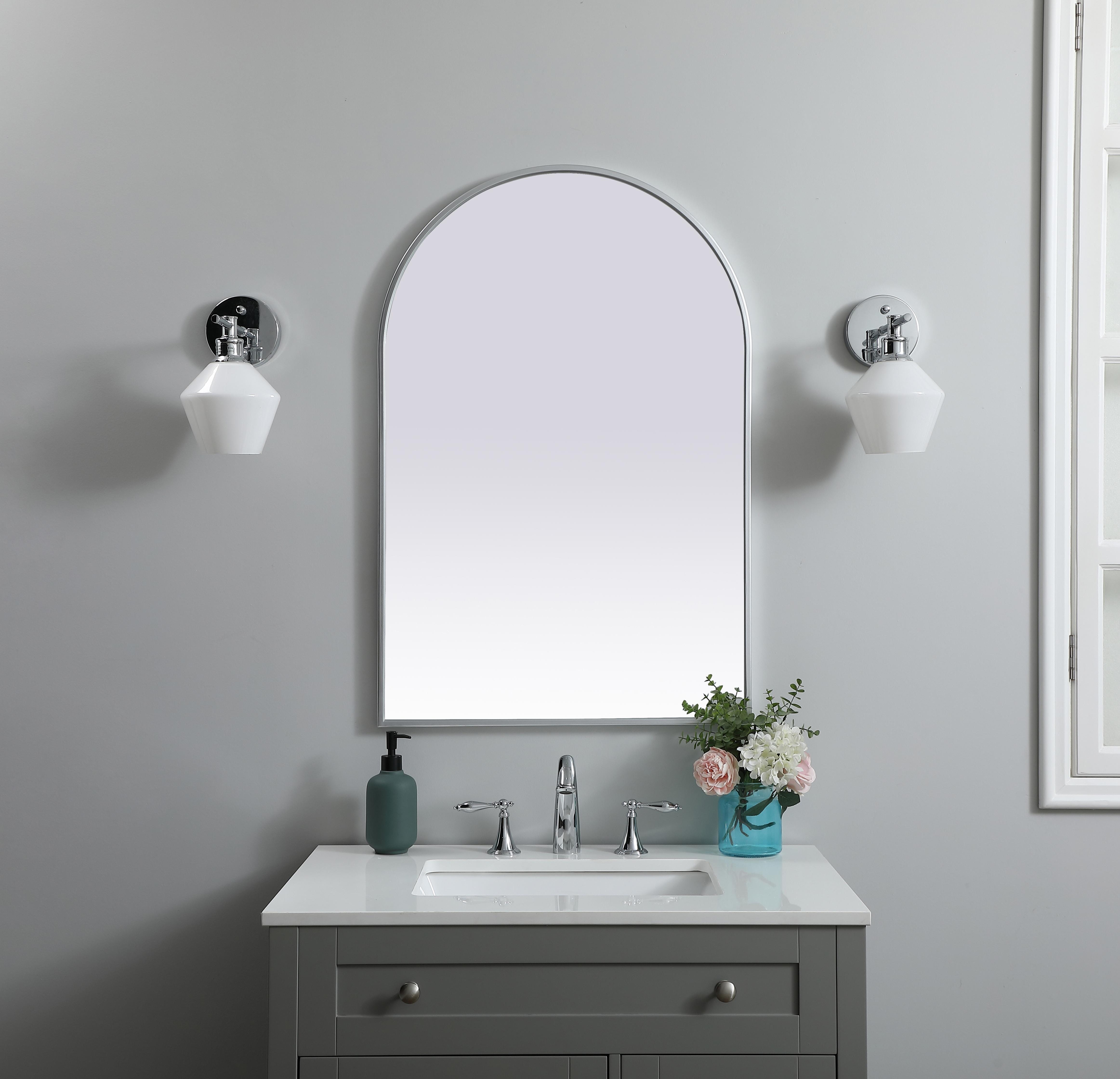 Instantly open up any space in your home with this minimalist wall-mounted mirror. Crafted of metal, this mirror strikes a round silhouette. Its slender, clean-lined frame sports a classic finish, while the glass mirror within features a flat, for a brilliant reflection, letting the light bounce off to expand your space. Designed in an arch shape, this metal-frame mirror showcases in the three available satin finishes in black, brass, or silver. Mount this work of art in any room of your choice for added visual impact. Collection: Ayra Finish: Silver Width: 24.00" Height: 36.00" Length: 36.00" Weight: 16.00 lb Material: iron and MDF Country of Origin: China Manufacturer Warranty: 1 year limited - alternate view