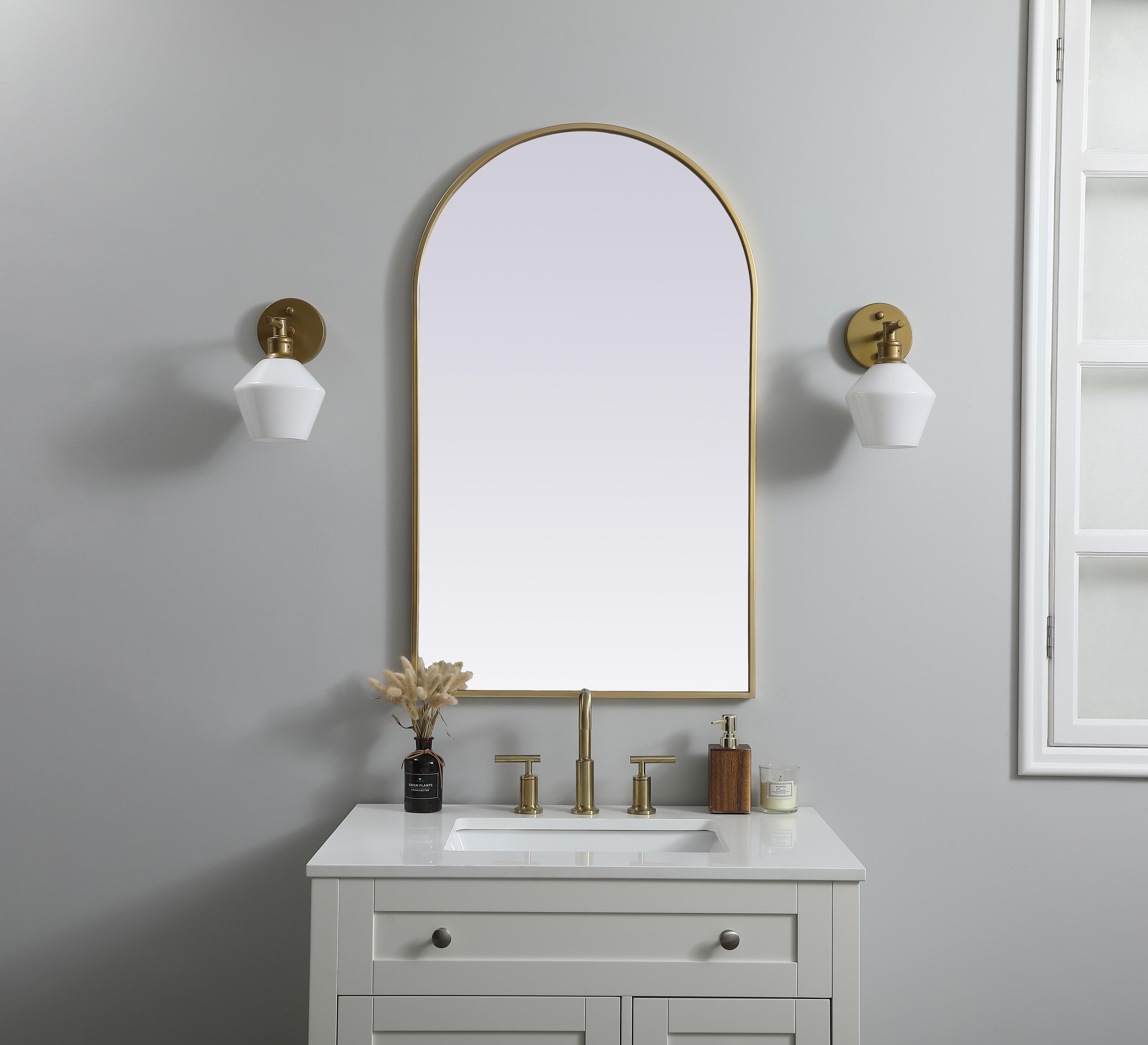 Instantly open up any space in your home with this minimalist wall-mounted mirror. Crafted of metal, this mirror strikes a round silhouette. Its slender, clean-lined frame sports a classic finish, while the glass mirror within features a flat, for a brilliant reflection, letting the light bounce off to expand your space. Designed in an arch shape, this metal-frame mirror showcases in the three available satin finishes in black, brass, or silver. Mount this work of art in any room of your choice for added visual impact. Collection: Ayra Finish: Brass Width: 24.00" Height: 40.00" Length: 40.00" Weight: 17.00 lb Material: iron and MDF Country of Origin: China Manufacturer Warranty: 1 year limited - alternate view