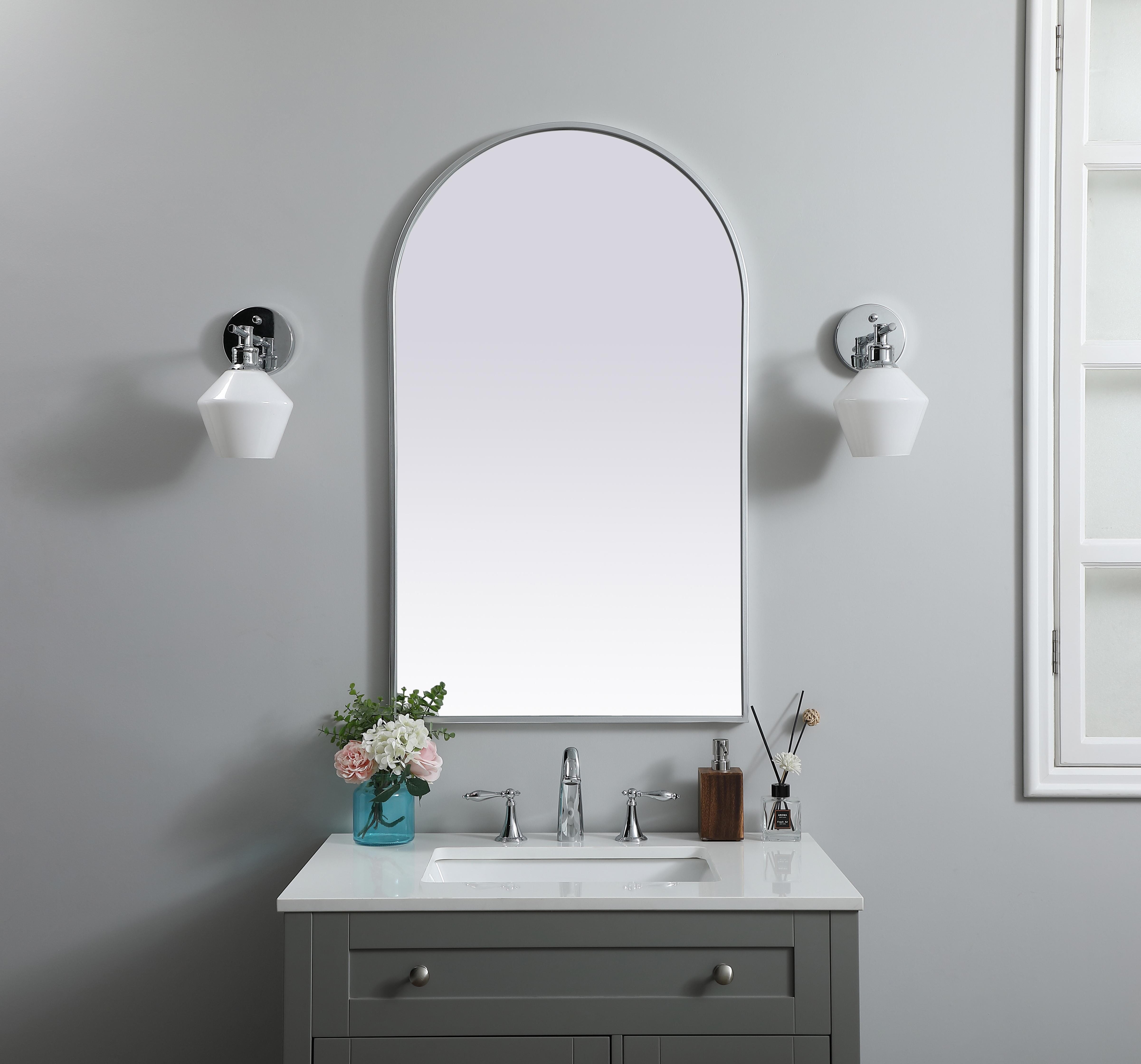 Instantly open up any space in your home with this minimalist wall-mounted mirror. Crafted of metal, this mirror strikes a round silhouette. Its slender, clean-lined frame sports a classic finish, while the glass mirror within features a flat, for a brilliant reflection, letting the light bounce off to expand your space. Designed in an arch shape, this metal-frame mirror showcases in the three available satin finishes in black, brass, or silver. Mount this work of art in any room of your choice for added visual impact. Collection: Ayra Finish: Silver Width: 24.00" Height: 40.00" Length: 40.00" Weight: 17.00 lb Material: iron and MDF Country of Origin: China Manufacturer Warranty: 1 year limited - alternate view