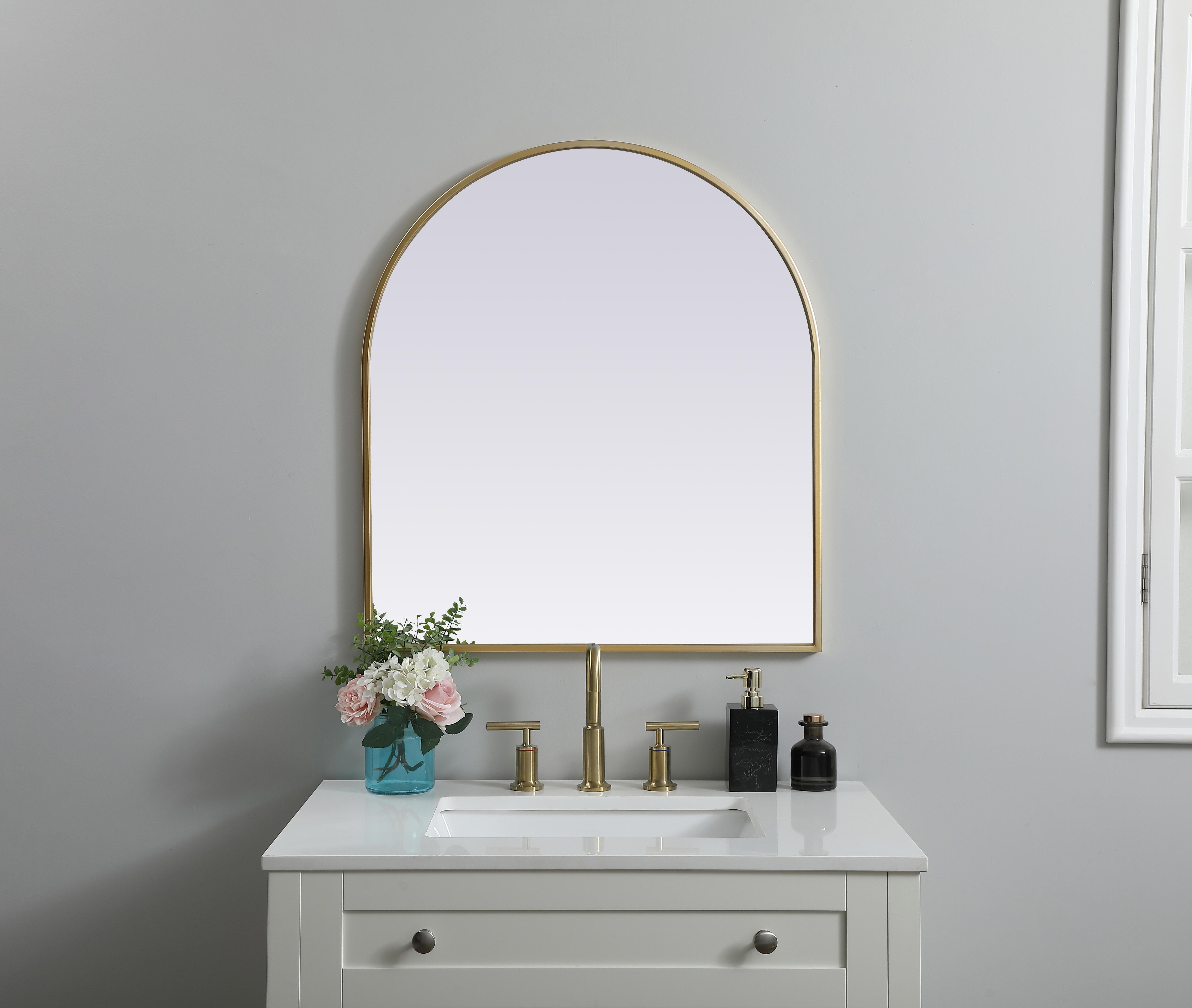 Instantly open up any space in your home with this minimalist wall-mounted mirror. Crafted of metal, this mirror strikes a round silhouette. Its slender, clean-lined frame sports a classic finish, while the glass mirror within features a flat, for a brilliant reflection, letting the light bounce off to expand your space. Designed in an arch shape, this metal-frame mirror showcases in the three available satin finishes in black, brass, or silver. Mount this work of art in any room of your choice for added visual impact. Collection: Ayra Finish: Brass Width: 27.00" Height: 30.00" Length: 30.00" Weight: 14.00 lb Material: iron and MDF Country of Origin: China Manufacturer Warranty: 1 year limited - alternate view