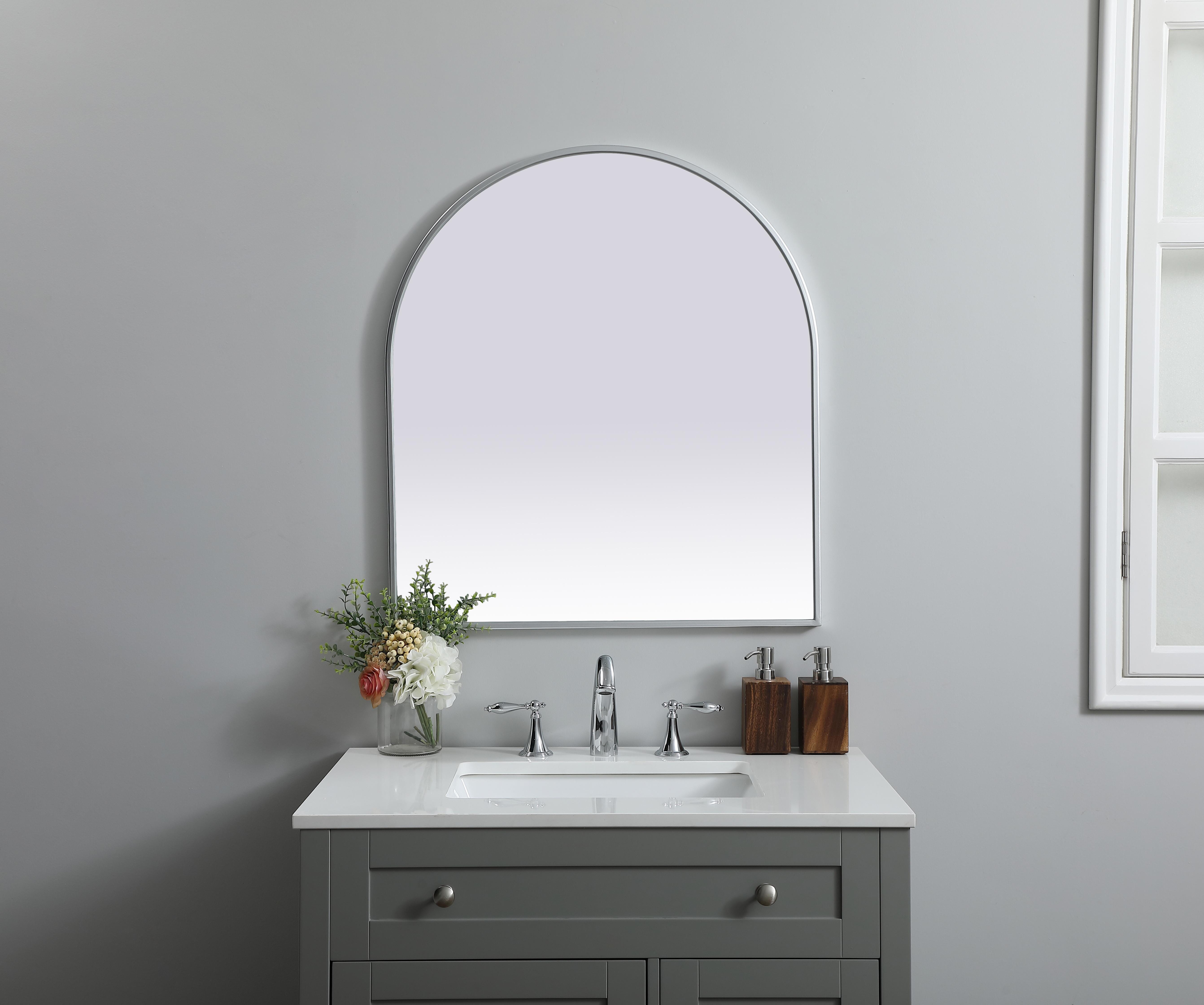 Instantly open up any space in your home with this minimalist wall-mounted mirror. Crafted of metal, this mirror strikes a round silhouette. Its slender, clean-lined frame sports a classic finish, while the glass mirror within features a flat, for a brilliant reflection, letting the light bounce off to expand your space. Designed in an arch shape, this metal-frame mirror showcases in the three available satin finishes in black, brass, or silver. Mount this work of art in any room of your choice for added visual impact. Collection: Ayra Finish: Silver Width: 27.00" Height: 30.00" Length: 30.00" Weight: 14.00 lb Material: iron and MDF Country of Origin: China Manufacturer Warranty: 1 year limited - alternate view