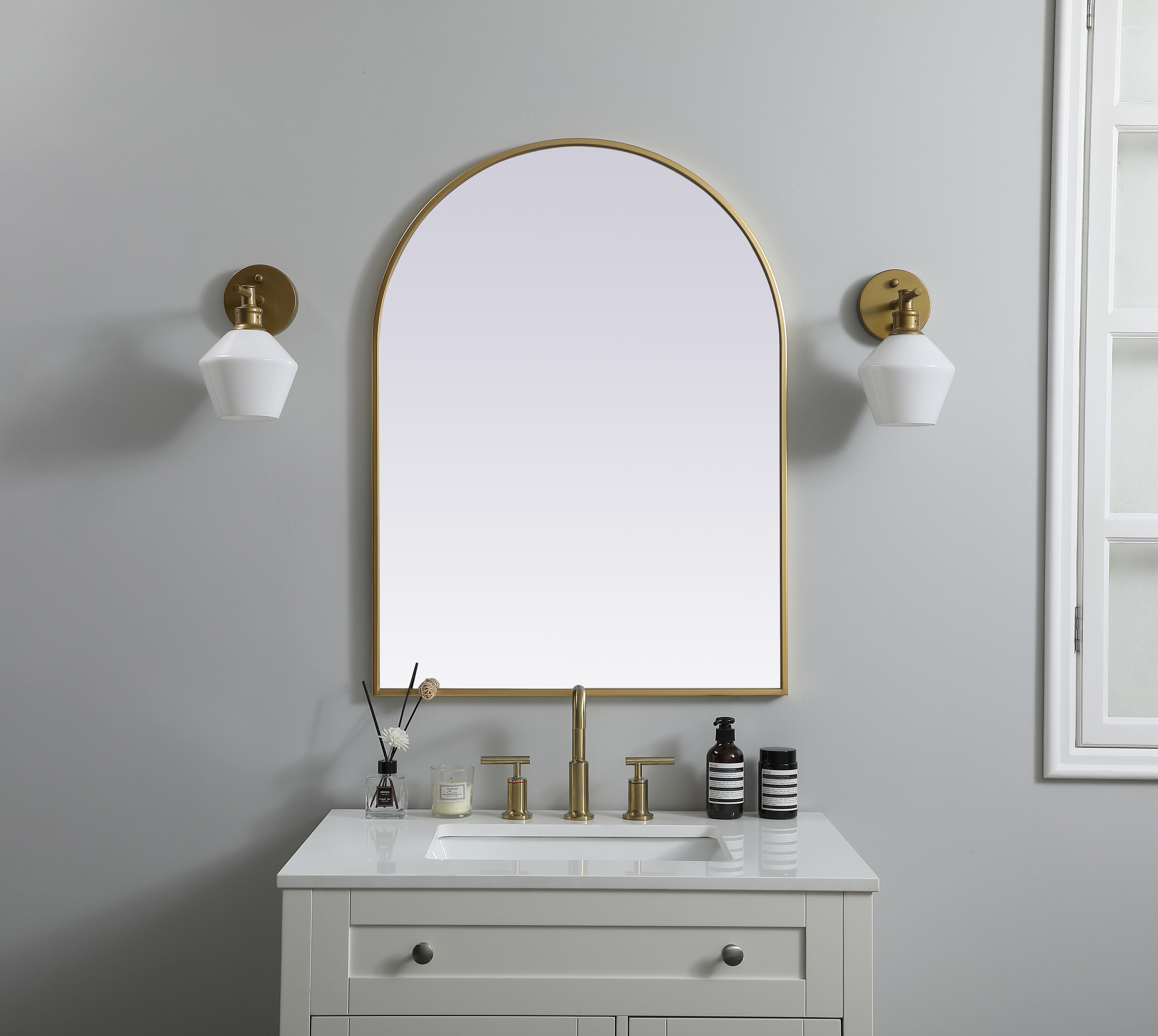 Instantly open up any space in your home with this minimalist wall-mounted mirror. Crafted of metal, this mirror strikes a round silhouette. Its slender, clean-lined frame sports a classic finish, while the glass mirror within features a flat, for a brilliant reflection, letting the light bounce off to expand your space. Designed in an arch shape, this metal-frame mirror showcases in the three available satin finishes in black, brass, or silver. Mount this work of art in any room of your choice for added visual impact. Collection: Ayra Finish: Brass Width: 27.00" Height: 36.00" Length: 36.00" Weight: 17.00 lb Material: iron and MDF Country of Origin: China Manufacturer Warranty: 1 year limited - alternate view
