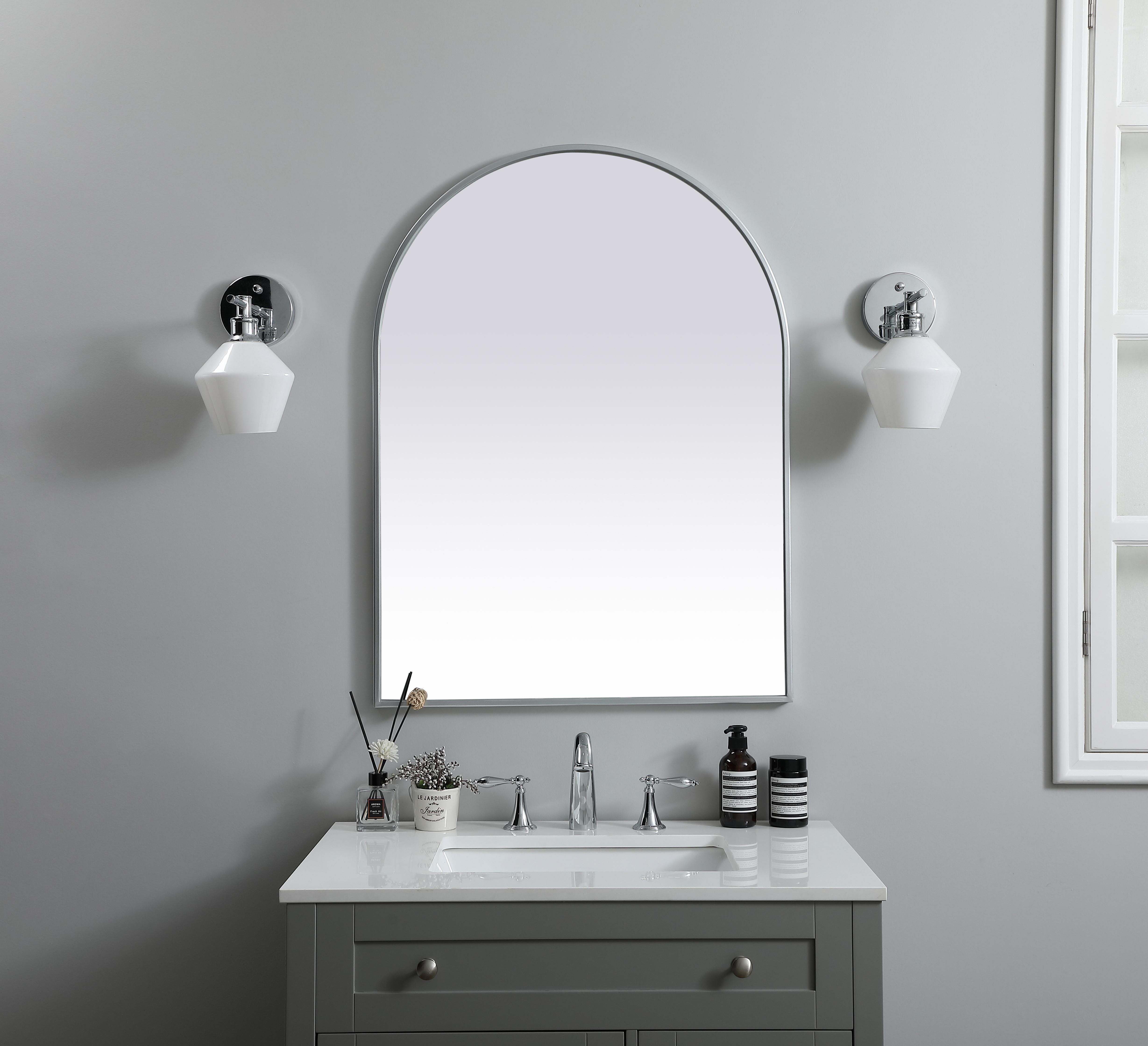 Instantly open up any space in your home with this minimalist wall-mounted mirror. Crafted of metal, this mirror strikes a round silhouette. Its slender, clean-lined frame sports a classic finish, while the glass mirror within features a flat, for a brilliant reflection, letting the light bounce off to expand your space. Designed in an arch shape, this metal-frame mirror showcases in the three available satin finishes in black, brass, or silver. Mount this work of art in any room of your choice for added visual impact. Collection: Ayra Finish: Silver Width: 27.00" Height: 36.00" Length: 36.00" Weight: 17.00 lb Material: iron and MDF Country of Origin: China Manufacturer Warranty: 1 year limited - alternate view