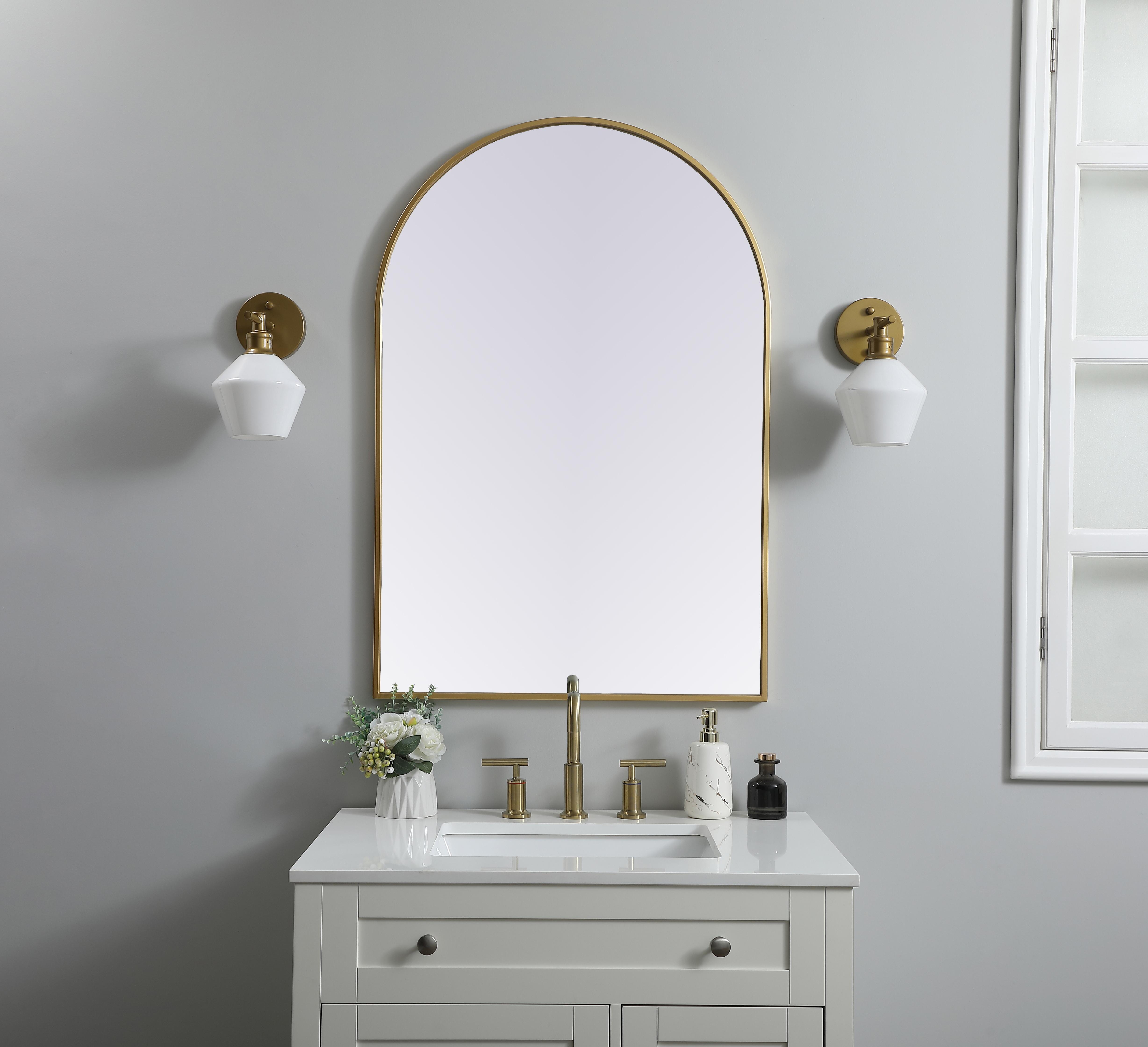 Instantly open up any space in your home with this minimalist wall-mounted mirror. Crafted of metal, this mirror strikes a round silhouette. Its slender, clean-lined frame sports a classic finish, while the glass mirror within features a flat, for a brilliant reflection, letting the light bounce off to expand your space. Designed in an arch shape, this metal-frame mirror showcases in the three available satin finishes in black, brass, or silver. Mount this work of art in any room of your choice for added visual impact. Collection: Ayra Finish: Brass Width: 27.00" Height: 40.00" Length: 40.00" Weight: 19.00 lb Material: iron and MDF Country of Origin: China Manufacturer Warranty: 1 year limited - alternate view