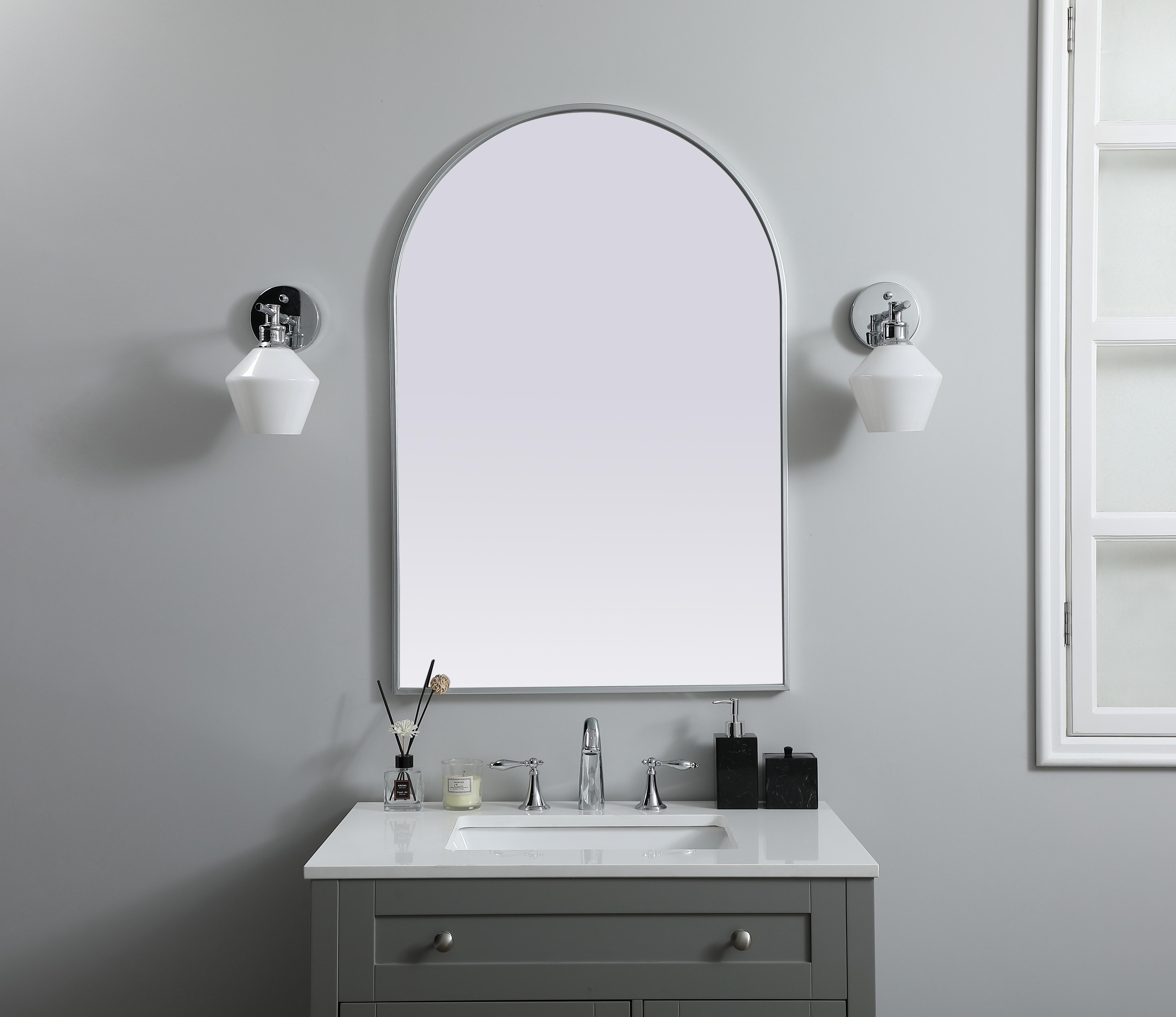 Instantly open up any space in your home with this minimalist wall-mounted mirror. Crafted of metal, this mirror strikes a round silhouette. Its slender, clean-lined frame sports a classic finish, while the glass mirror within features a flat, for a brilliant reflection, letting the light bounce off to expand your space. Designed in an arch shape, this metal-frame mirror showcases in the three available satin finishes in black, brass, or silver. Mount this work of art in any room of your choice for added visual impact. Collection: Ayra Finish: Silver Width: 27.00" Height: 40.00" Length: 40.00" Weight: 19.00 lb Material: iron and MDF Country of Origin: China Manufacturer Warranty: 1 year limited - alternate view
