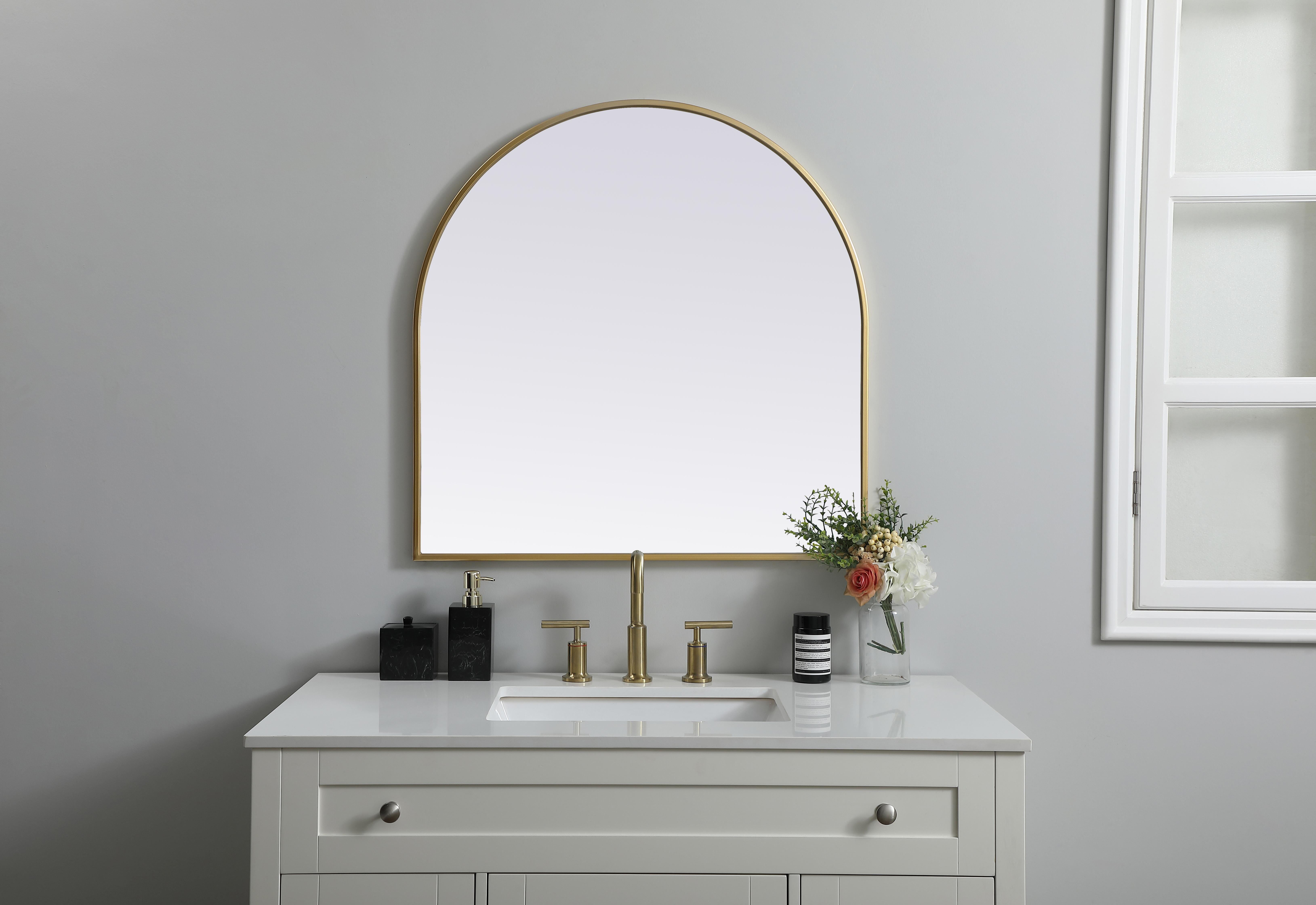 Instantly open up any space in your home with this minimalist wall-mounted mirror. Crafted of metal, this mirror strikes a round silhouette. Its slender, clean-lined frame sports a classic finish, while the glass mirror within features a flat, for a brilliant reflection, letting the light bounce off to expand your space. Designed in an arch shape, this metal-frame mirror showcases in the three available satin finishes in black, brass, or silver. Mount this work of art in any room of your choice for added visual impact. Collection: Ayra Finish: Brass Width: 30.00" Height: 30.00" Length: 30.00" Weight: 16.00 lb Material: iron and MDF Country of Origin: China Manufacturer Warranty: 1 year limited - alternate view