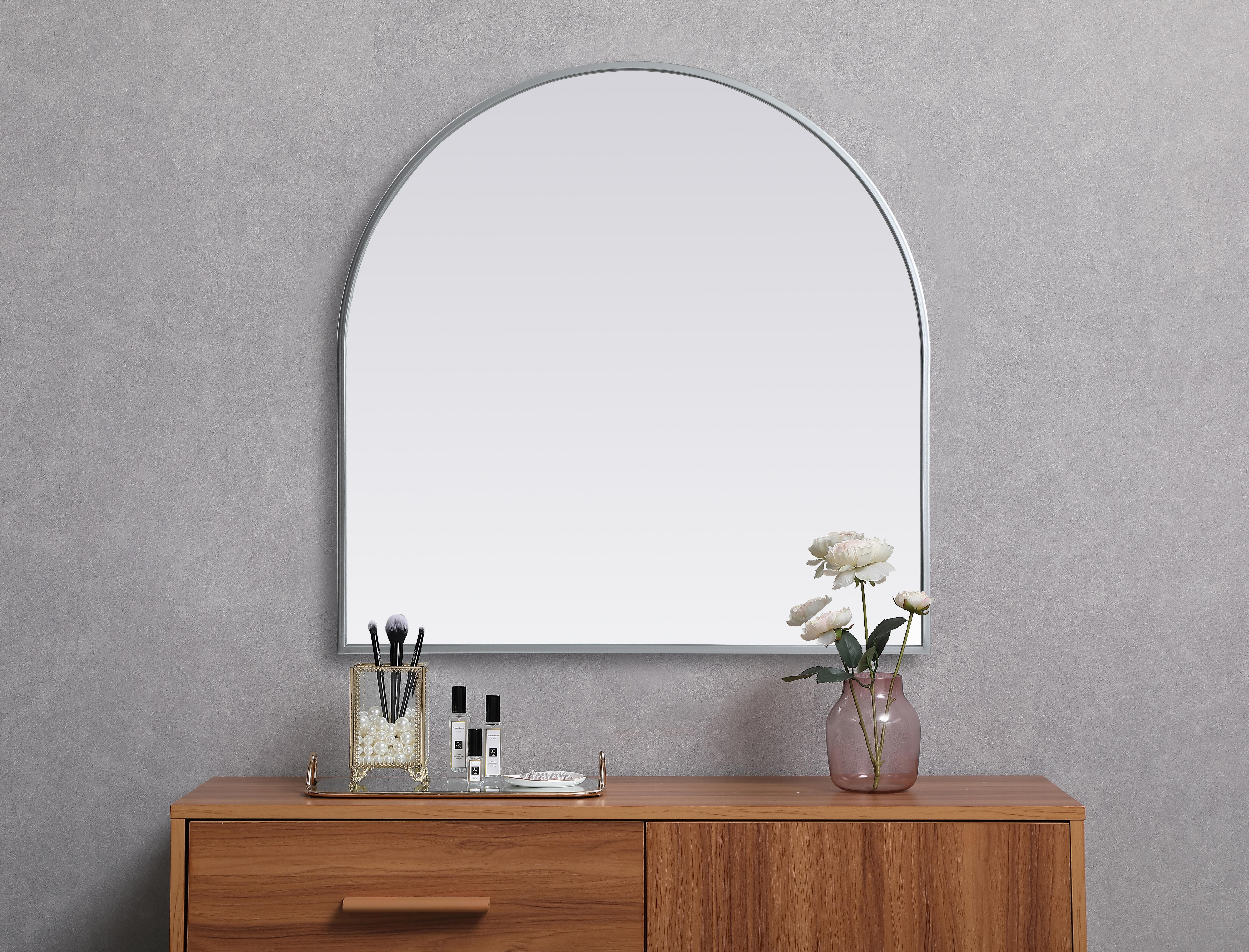 Instantly open up any space in your home with this minimalist wall-mounted mirror. Crafted of metal, this mirror strikes a round silhouette. Its slender, clean-lined frame sports a classic finish, while the glass mirror within features a flat, for a brilliant reflection, letting the light bounce off to expand your space. Designed in an arch shape, this metal-frame mirror showcases in the three available satin finishes in black, brass, or silver. Mount this work of art in any room of your choice for added visual impact. Collection: Ayra Finish: Silver Width: 30.00" Height: 30.00" Length: 30.00" Weight: 16.00 lb Material: iron and MDF Country of Origin: China Manufacturer Warranty: 1 year limited - alternate view