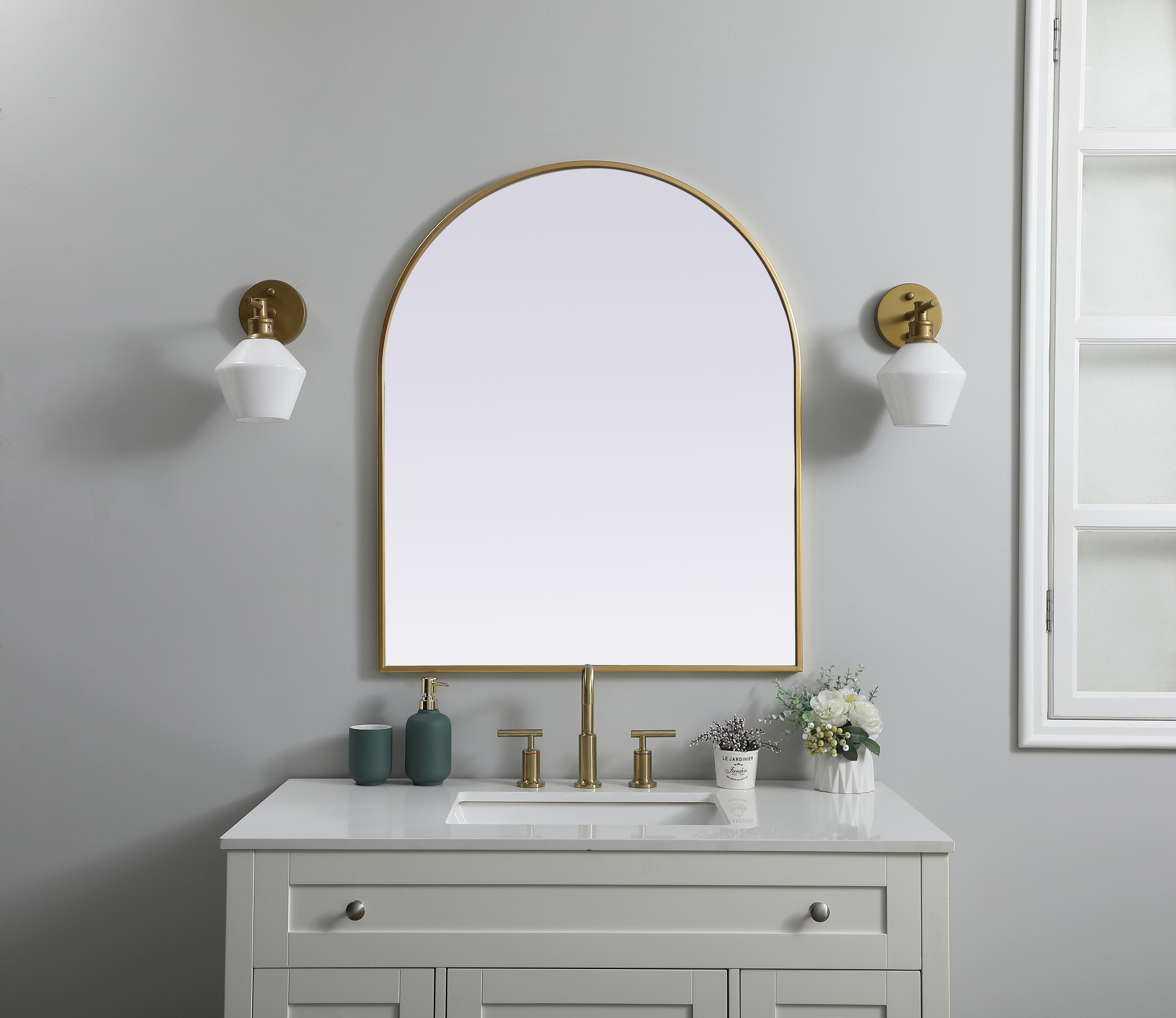 Instantly open up any space in your home with this minimalist wall-mounted mirror. Crafted of metal, this mirror strikes a round silhouette. Its slender, clean-lined frame sports a classic finish, while the glass mirror within features a flat, for a brilliant reflection, letting the light bounce off to expand your space. Designed in an arch shape, this metal-frame mirror showcases in the three available satin finishes in black, brass, or silver. Mount this work of art in any room of your choice for added visual impact. Collection: Ayra Finish: Brass Width: 30.00" Height: 36.00" Length: 36.00" Weight: 19.00 lb Material: iron and MDF Country of Origin: China Manufacturer Warranty: 1 year limited - alternate view