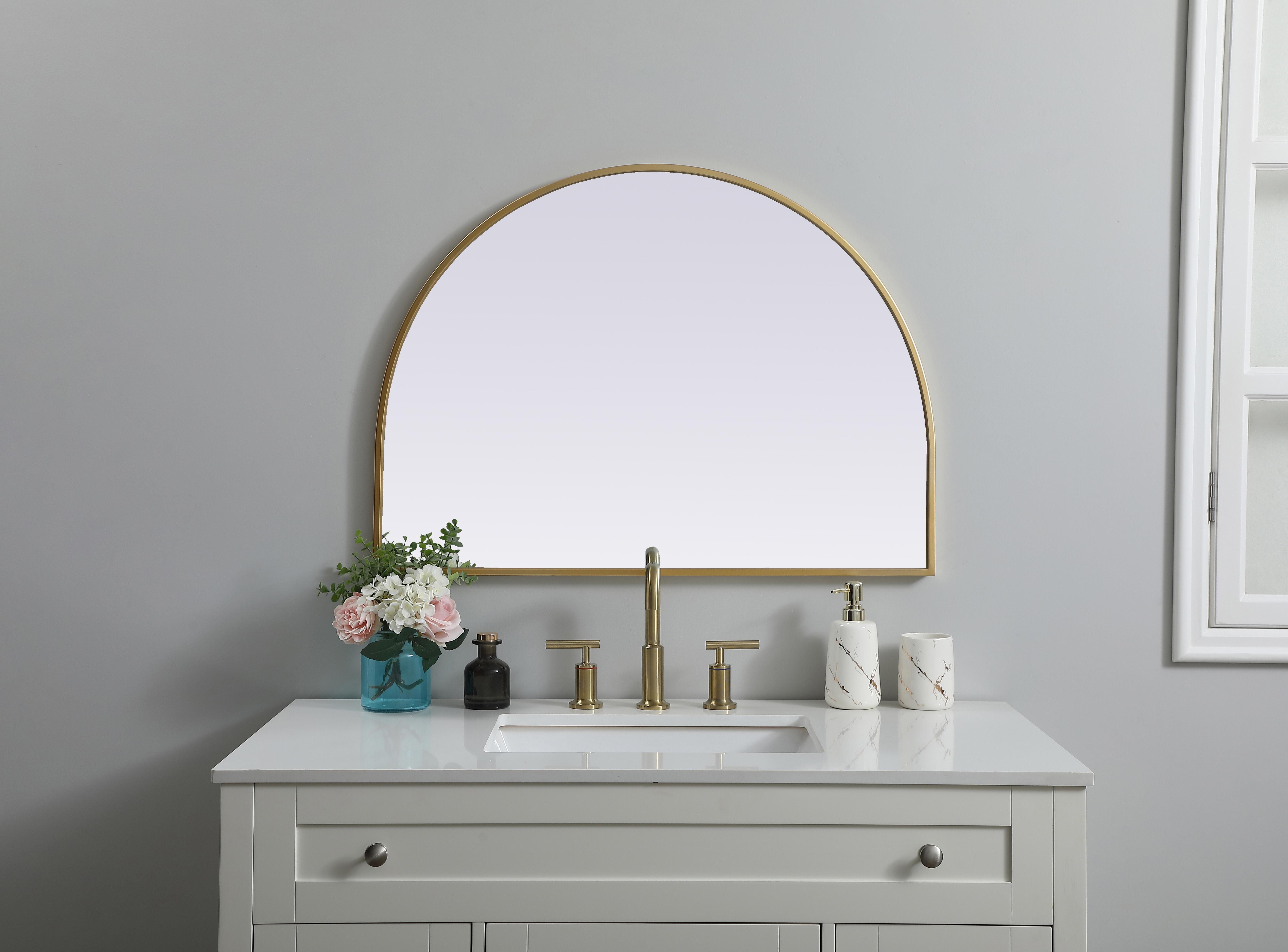 Instantly open up any space in your home with this minimalist wall-mounted mirror. Crafted of metal, this mirror strikes a round silhouette. Its slender, clean-lined frame sports a classic finish, while the glass mirror within features a flat, for a brilliant reflection, letting the light bounce off to expand your space. Designed in an arch shape, this metal-frame mirror showcases in the three available satin finishes in black, brass, or silver. Mount this work of art in any room of your choice for added visual impact. Collection: Ayra Finish: Brass Width: 33.00" Height: 24.00" Length: 24.00" Weight: 13.00 lb Material: iron and MDF Country of Origin: China Manufacturer Warranty: 1 year limited - alternate view