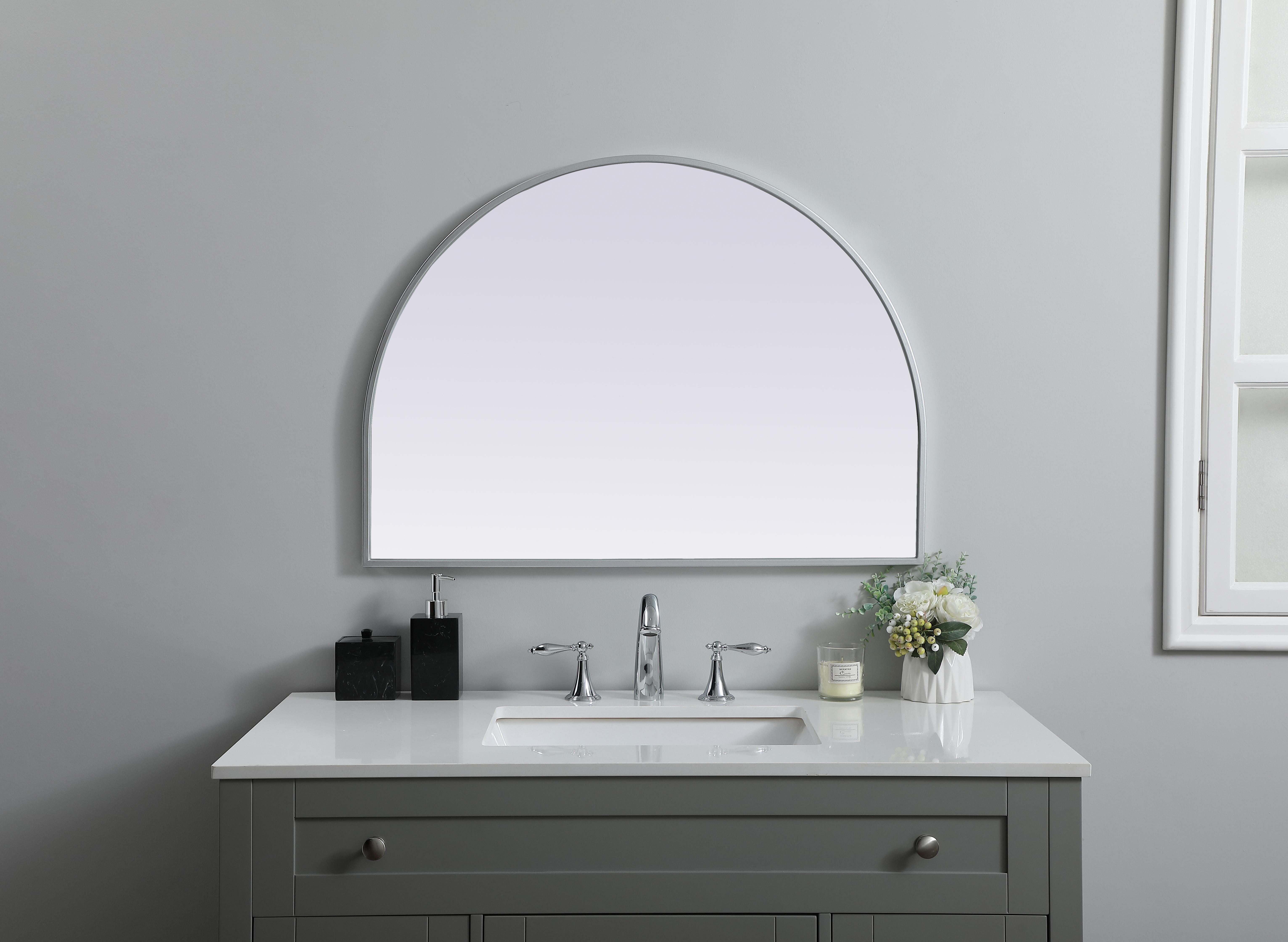 Instantly open up any space in your home with this minimalist wall-mounted mirror. Crafted of metal, this mirror strikes a round silhouette. Its slender, clean-lined frame sports a classic finish, while the glass mirror within features a flat, for a brilliant reflection, letting the light bounce off to expand your space. Designed in an arch shape, this metal-frame mirror showcases in the three available satin finishes in black, brass, or silver. Mount this work of art in any room of your choice for added visual impact. Collection: Ayra Finish: Silver Width: 33.00" Height: 24.00" Length: 24.00" Weight: 13.00 lb Material: iron and MDF Country of Origin: China Manufacturer Warranty: 1 year limited - alternate view