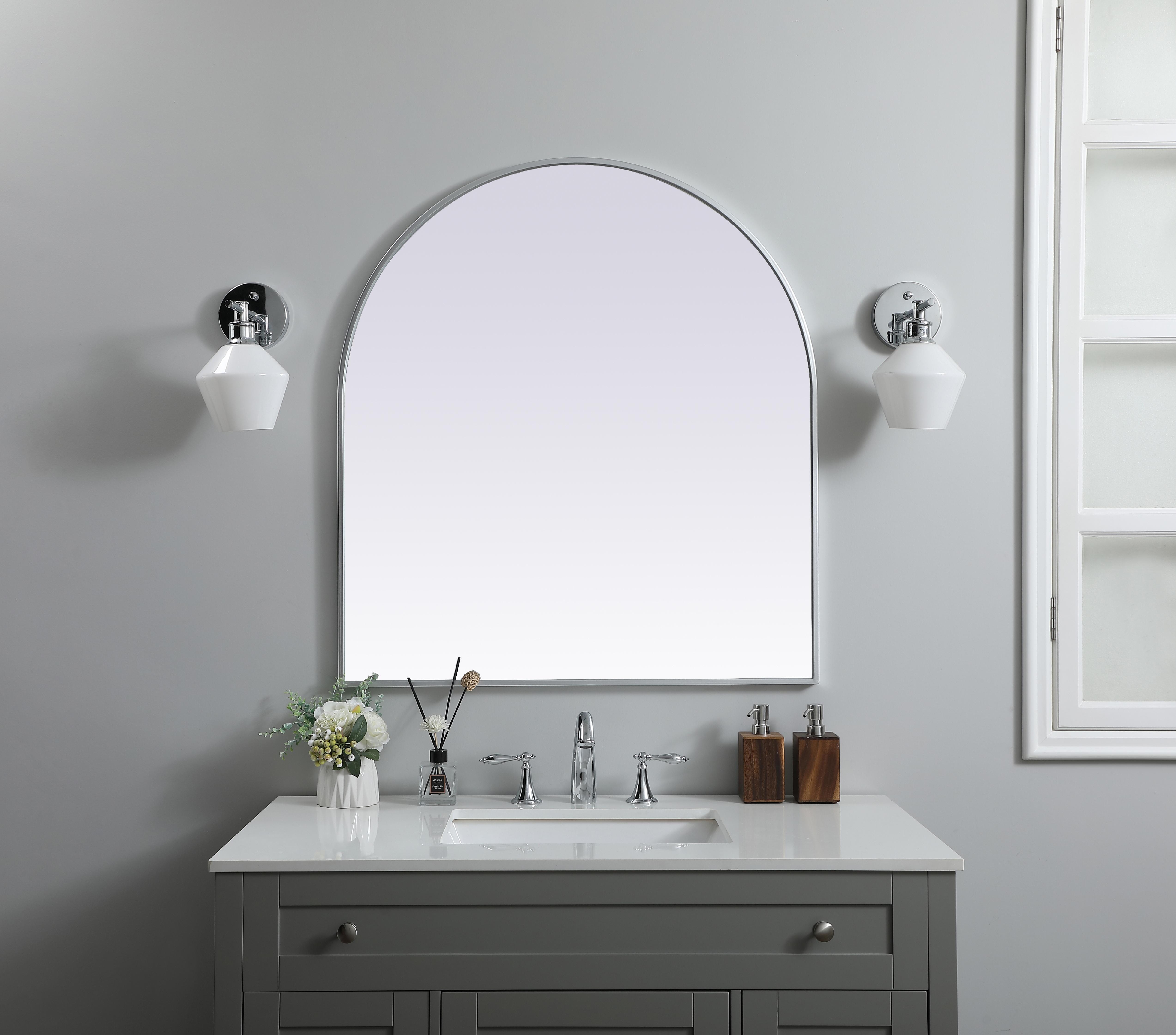 Instantly open up any space in your home with this minimalist wall-mounted mirror. Crafted of metal, this mirror strikes a round silhouette. Its slender, clean-lined frame sports a classic finish, while the glass mirror within features a flat, for a brilliant reflection, letting the light bounce off to expand your space. Designed in an arch shape, this metal-frame mirror showcases in the three available satin finishes in black, brass, or silver. Mount this work of art in any room of your choice for added visual impact. Collection: Ayra Finish: Silver Width: 33.00" Height: 36.00" Length: 36.00" Weight: 21.00 lb Material: iron and MDF Country of Origin: China Manufacturer Warranty: 1 year limited - alternate view
