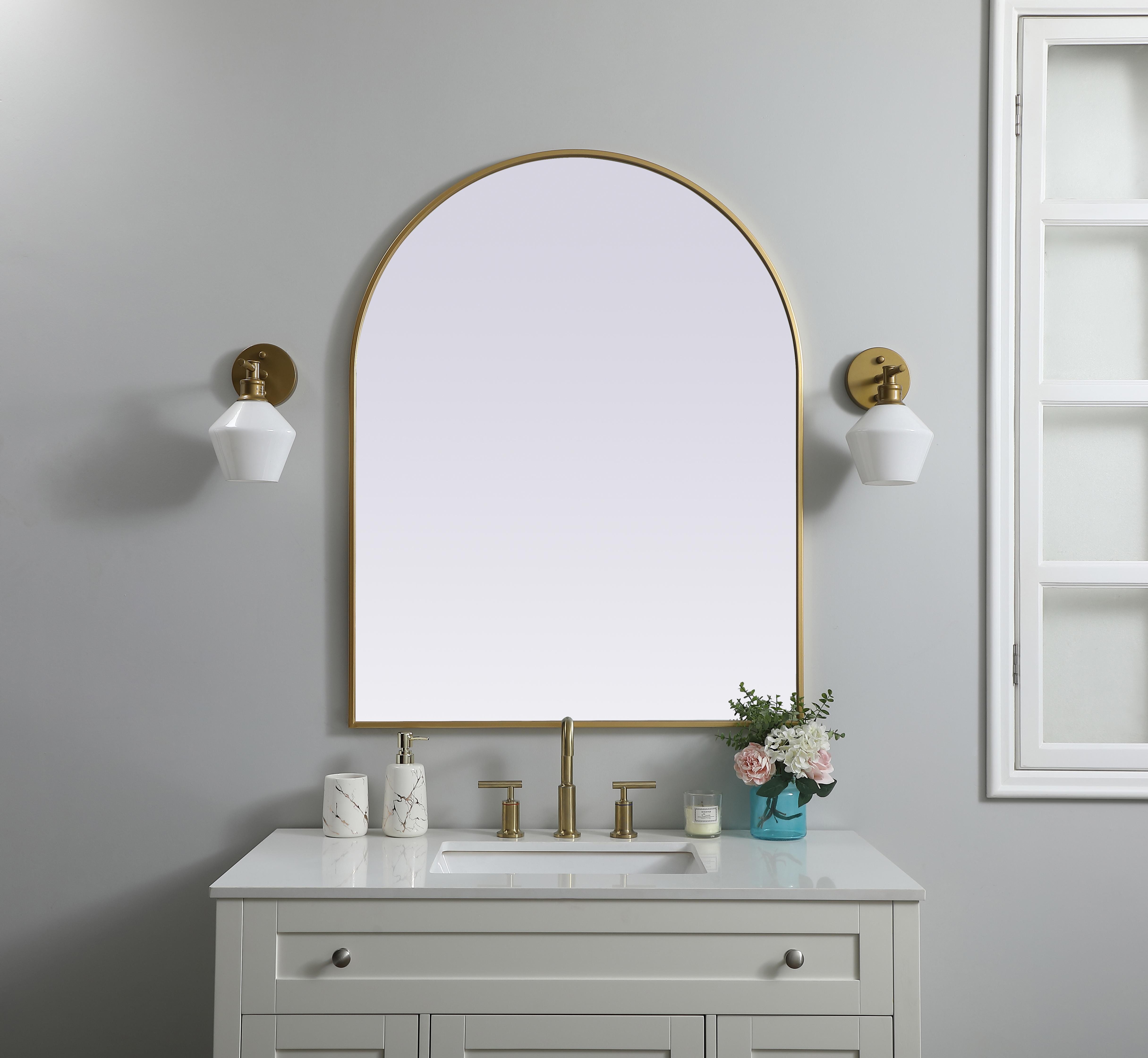 Instantly open up any space in your home with this minimalist wall-mounted mirror. Crafted of metal, this mirror strikes a round silhouette. Its slender, clean-lined frame sports a classic finish, while the glass mirror within features a flat, for a brilliant reflection, letting the light bounce off to expand your space. Designed in an arch shape, this metal-frame mirror showcases in the three available satin finishes in black, brass, or silver. Mount this work of art in any room of your choice for added visual impact. Collection: Ayra Finish: Brass Width: 33.00" Height: 42.00" Length: 42.00" Weight: 24.00 lb Material: iron and MDF Country of Origin: China Manufacturer Warranty: 1 year limited - alternate view