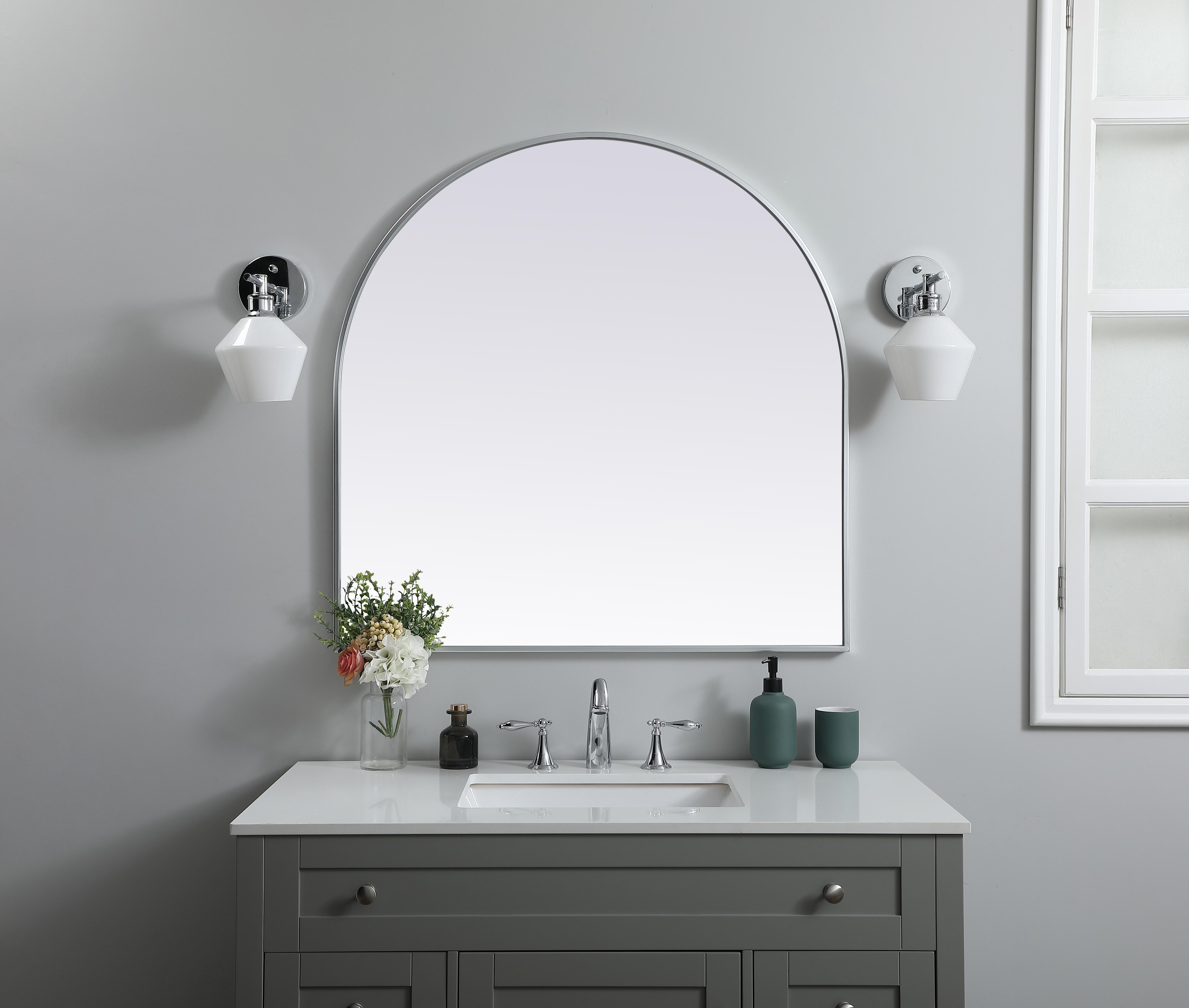 Instantly open up any space in your home with this minimalist wall-mounted mirror. Crafted of metal, this mirror strikes a round silhouette. Its slender, clean-lined frame sports a classic finish, while the glass mirror within features a flat, for a brilliant reflection, letting the light bounce off to expand your space. Designed in an arch shape, this metal-frame mirror showcases in the three available satin finishes in black, brass, or silver. Mount this work of art in any room of your choice for added visual impact. Collection: Ayra Finish: Silver Width: 36.00" Height: 36.00" Length: 36.00" Weight: 22.00 lb Material: iron and MDF Country of Origin: China Manufacturer Warranty: 1 year limited - alternate view