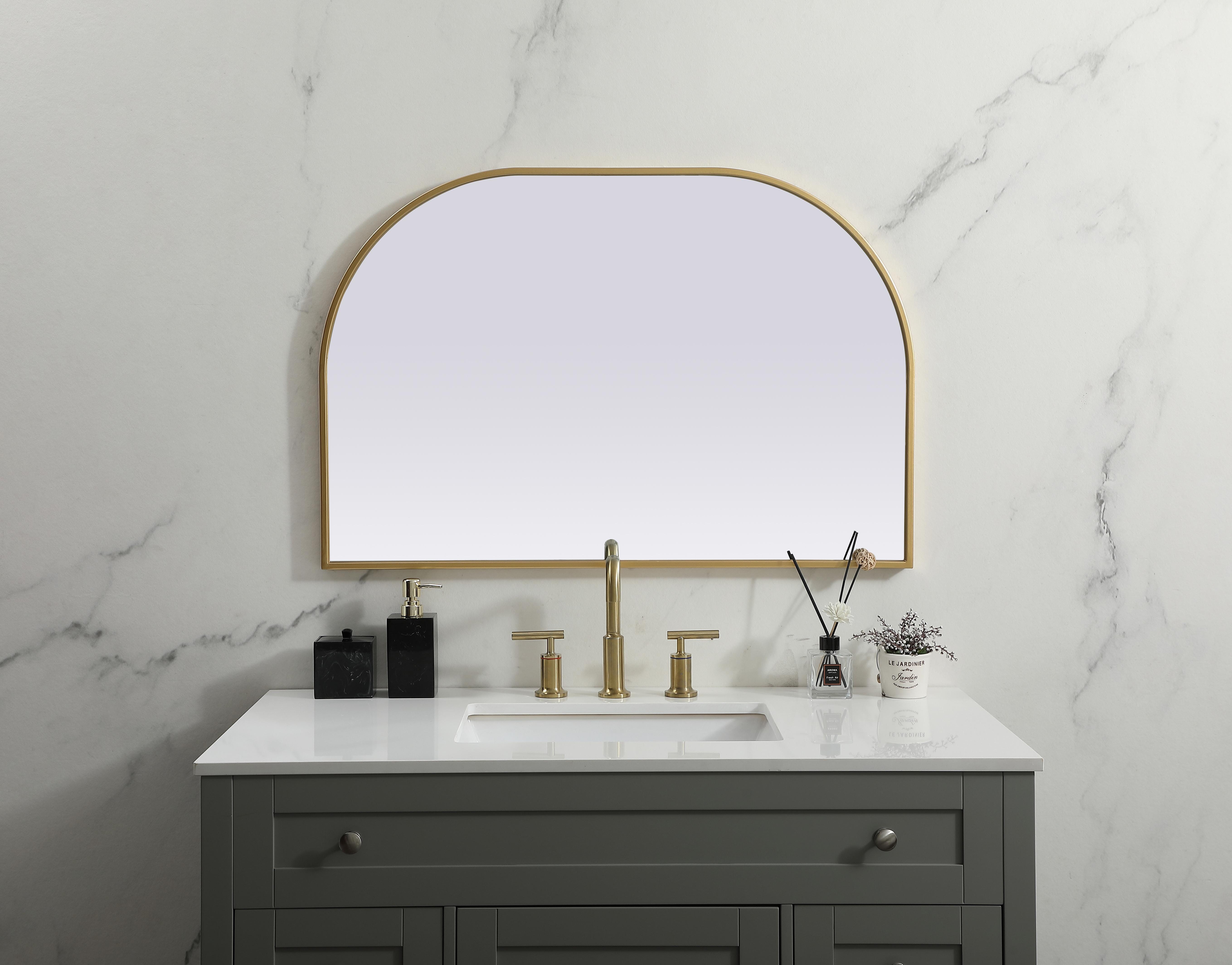 Over the mantel mirror serves an ideal décor on the mantel because it acts as an anchor piece that you can accentuate around with smaller accessories. The reflective qualities of the mirror can also make a space look bigger and brighter since it bounces light coming from your light sources. Designed with square bottom edges and rounded top, this mirror gives an unexpected twist to your typical mirror look. Select from three satin finishes in black, brass, or silver. Collection: Blaire Finish: Brass Width: 36.00" Height: 24.00" Length: 24.00" Weight: 16.00 lb Material: iron and MDF Country of Origin: China Manufacturer Warranty: 1 year limited - alternate view