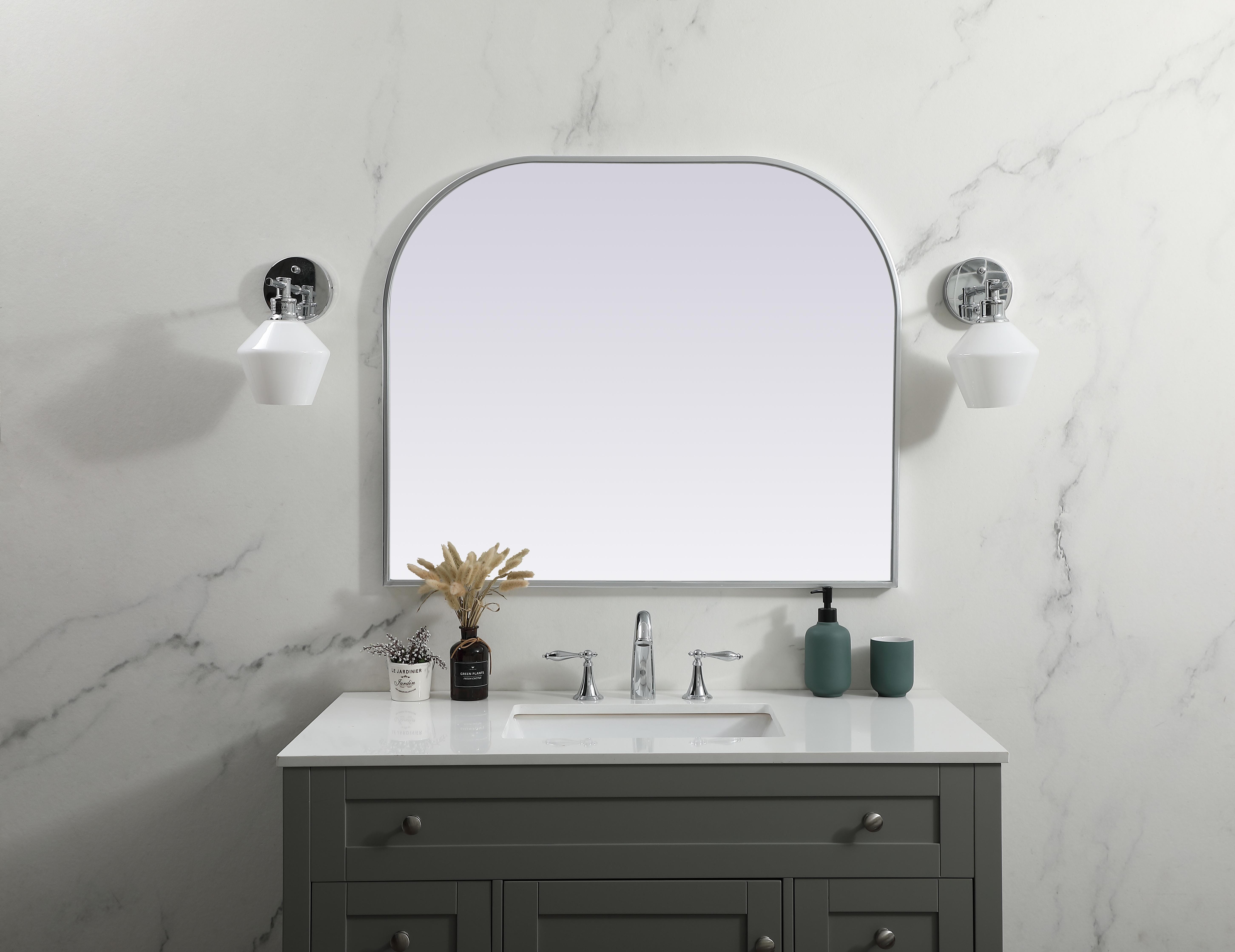Over the mantel mirror serves an ideal décor on the mantel because it acts as an anchor piece that you can accentuate around with smaller accessories. The reflective qualities of the mirror can also make a space look bigger and brighter since it bounces light coming from your light sources. Designed with square bottom edges and rounded top, this mirror gives an unexpected twist to your typical mirror look. Select from three satin finishes in black, brass, or silver. Collection: Blaire Finish: Silver Width: 36.00" Height: 30.00" Length: 30.00" Weight: 20.00 lb Material: iron and MDF Country of Origin: China Manufacturer Warranty: 1 year limited - alternate view