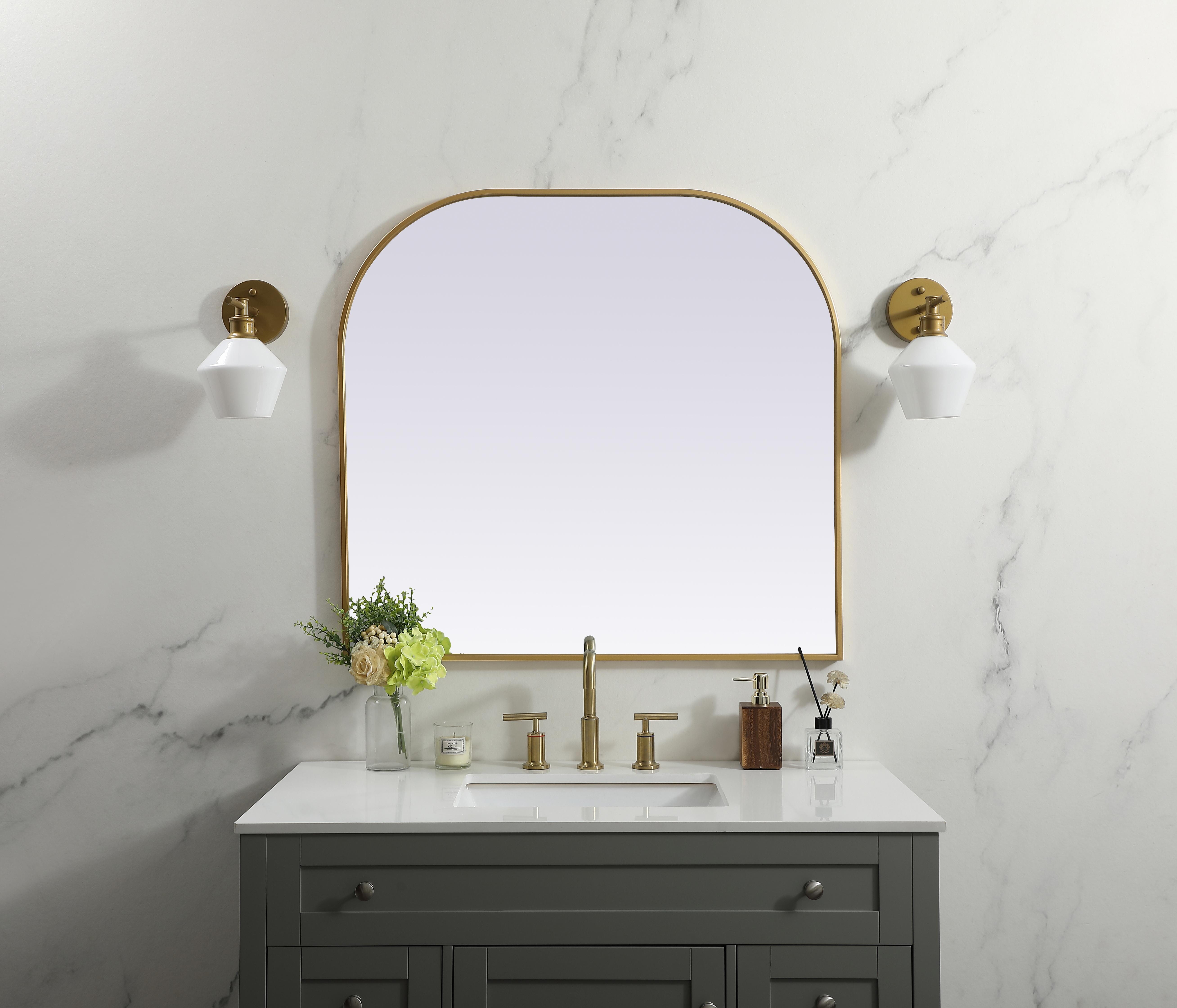 Over the mantel mirror serves an ideal décor on the mantel because it acts as an anchor piece that you can accentuate around with smaller accessories. The reflective qualities of the mirror can also make a space look bigger and brighter since it bounces light coming from your light sources. Designed with square bottom edges and rounded top, this mirror gives an unexpected twist to your typical mirror look. Select from three satin finishes in black, brass, or silver. Collection: Blaire Finish: Brass Width: 36.00" Height: 34.00" Length: 34.00" Weight: 22.00 lb Material: iron and MDF Country of Origin: China Manufacturer Warranty: 1 year limited - alternate view