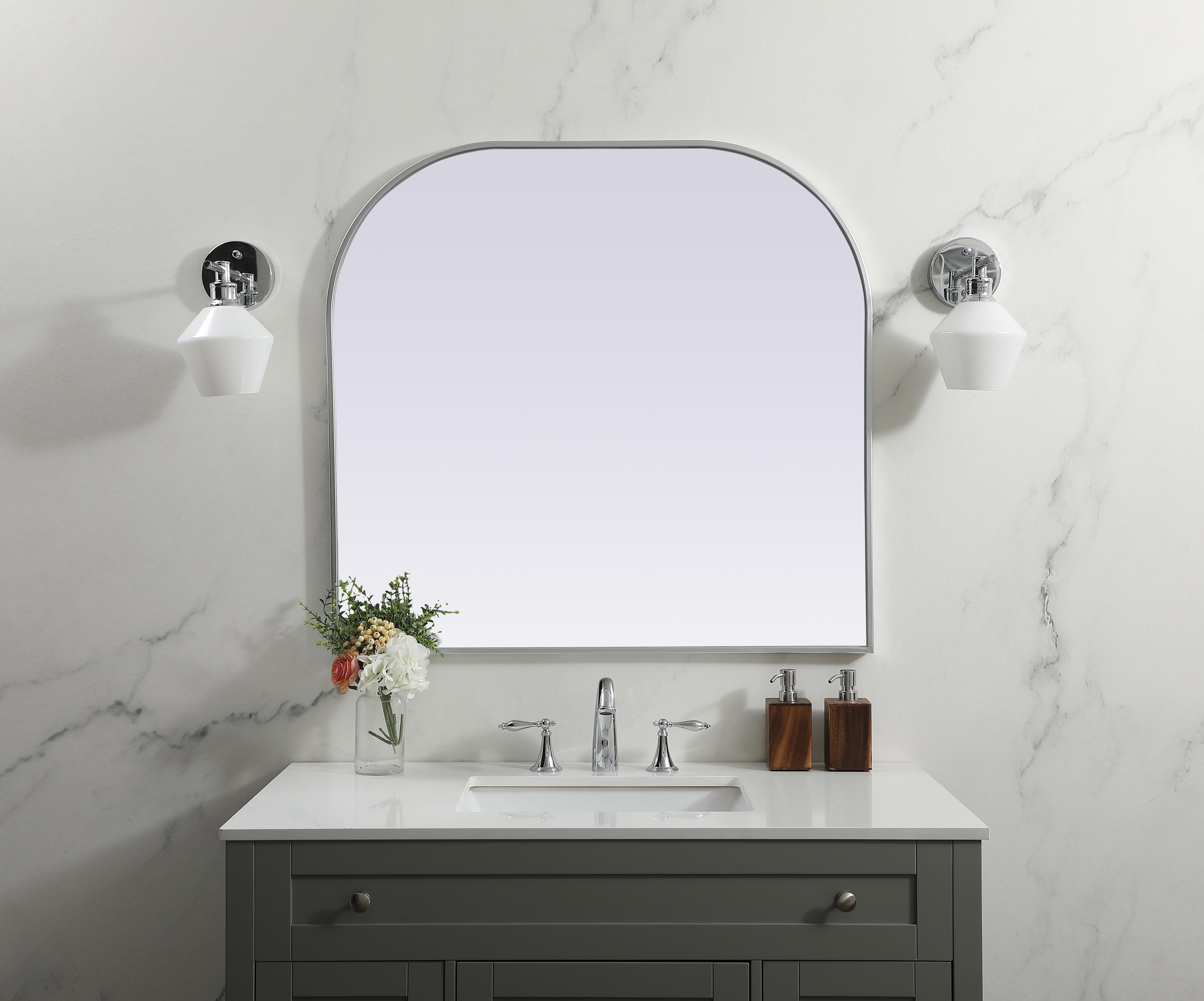 Over the mantel mirror serves an ideal décor on the mantel because it acts as an anchor piece that you can accentuate around with smaller accessories. The reflective qualities of the mirror can also make a space look bigger and brighter since it bounces light coming from your light sources. Designed with square bottom edges and rounded top, this mirror gives an unexpected twist to your typical mirror look. Select from three satin finishes in black, brass, or silver. Collection: Blaire Finish: Silver Width: 36.00" Height: 34.00" Length: 34.00" Weight: 22.00 lb Material: iron and MDF Country of Origin: China Manufacturer Warranty: 1 year limited - alternate view
