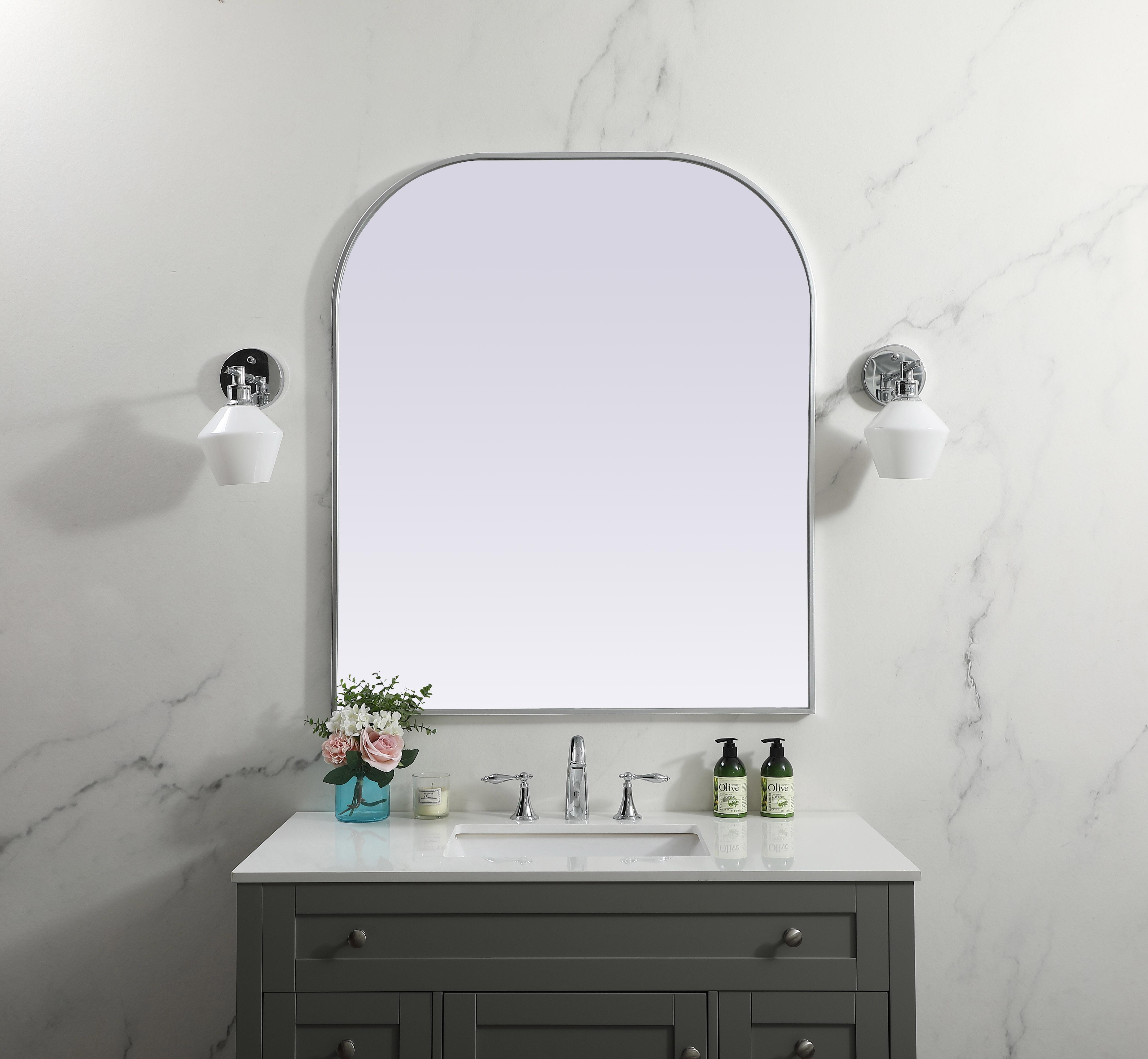 Over the mantel mirror serves an ideal décor on the mantel because it acts as an anchor piece that you can accentuate around with smaller accessories. The reflective qualities of the mirror can also make a space look bigger and brighter since it bounces light coming from your light sources. Designed with square bottom edges and rounded top, this mirror gives an unexpected twist to your typical mirror look. Select from three satin finishes in black, brass, or silver. Collection: Blaire Finish: Silver Width: 36.00" Height: 42.00" Length: 42.00" Weight: 27.00 lb Material: iron and MDF Country of Origin: China Manufacturer Warranty: 1 year limited - alternate view