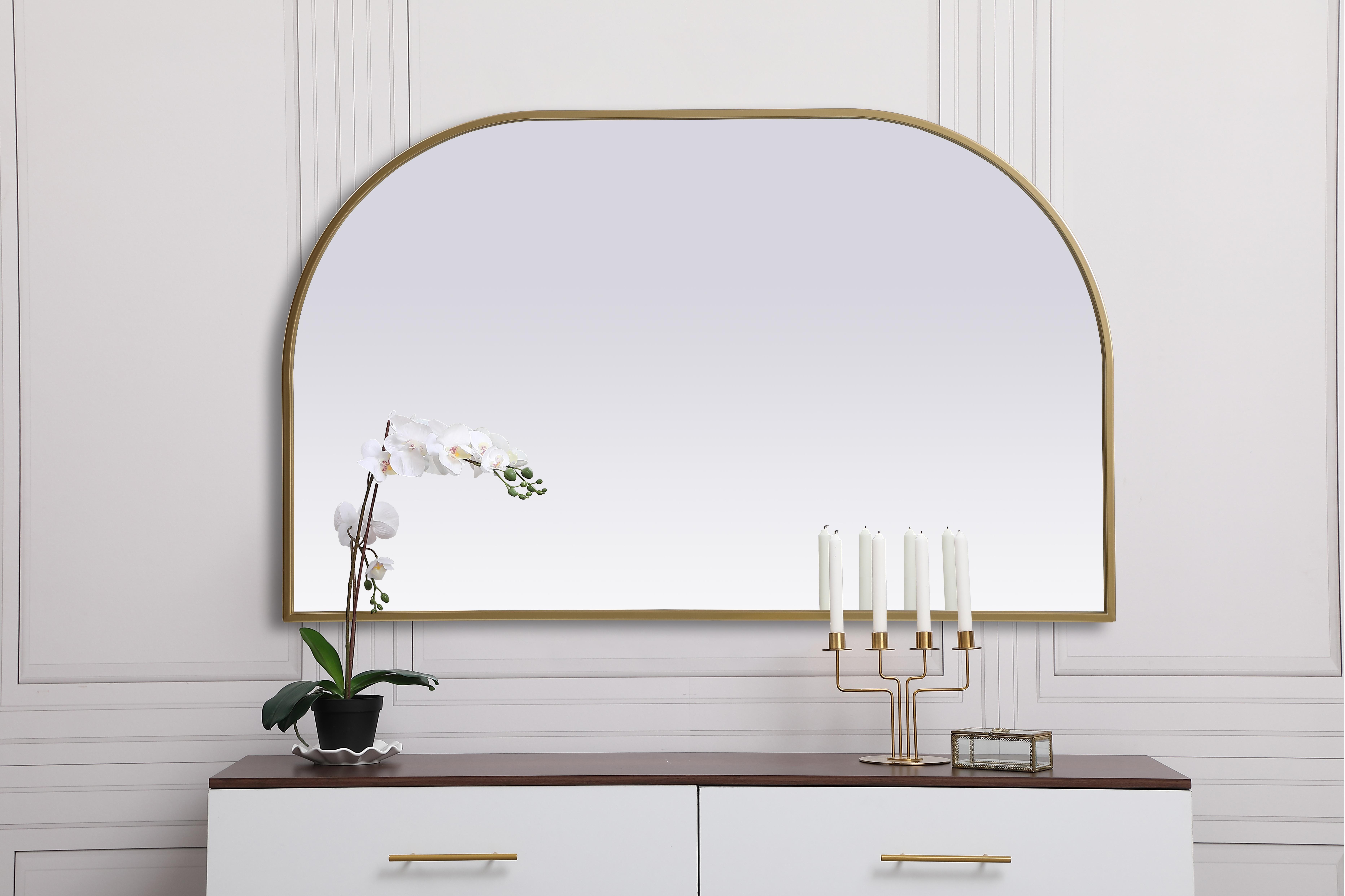Over the mantel mirror serves an ideal décor on the mantel because it acts as an anchor piece that you can accentuate around with smaller accessories. The reflective qualities of the mirror can also make a space look bigger and brighter since it bounces light coming from your light sources. Designed with square bottom edges and rounded top, this mirror gives an unexpected twist to your typical mirror look. Select from three satin finishes in black, brass, or silver. Collection: Blaire Finish: Brass Width: 39.00" Height: 24.00" Length: 24.00" Weight: 17.00 lb Material: iron and MDF Country of Origin: China Manufacturer Warranty: 1 year limited - alternate view