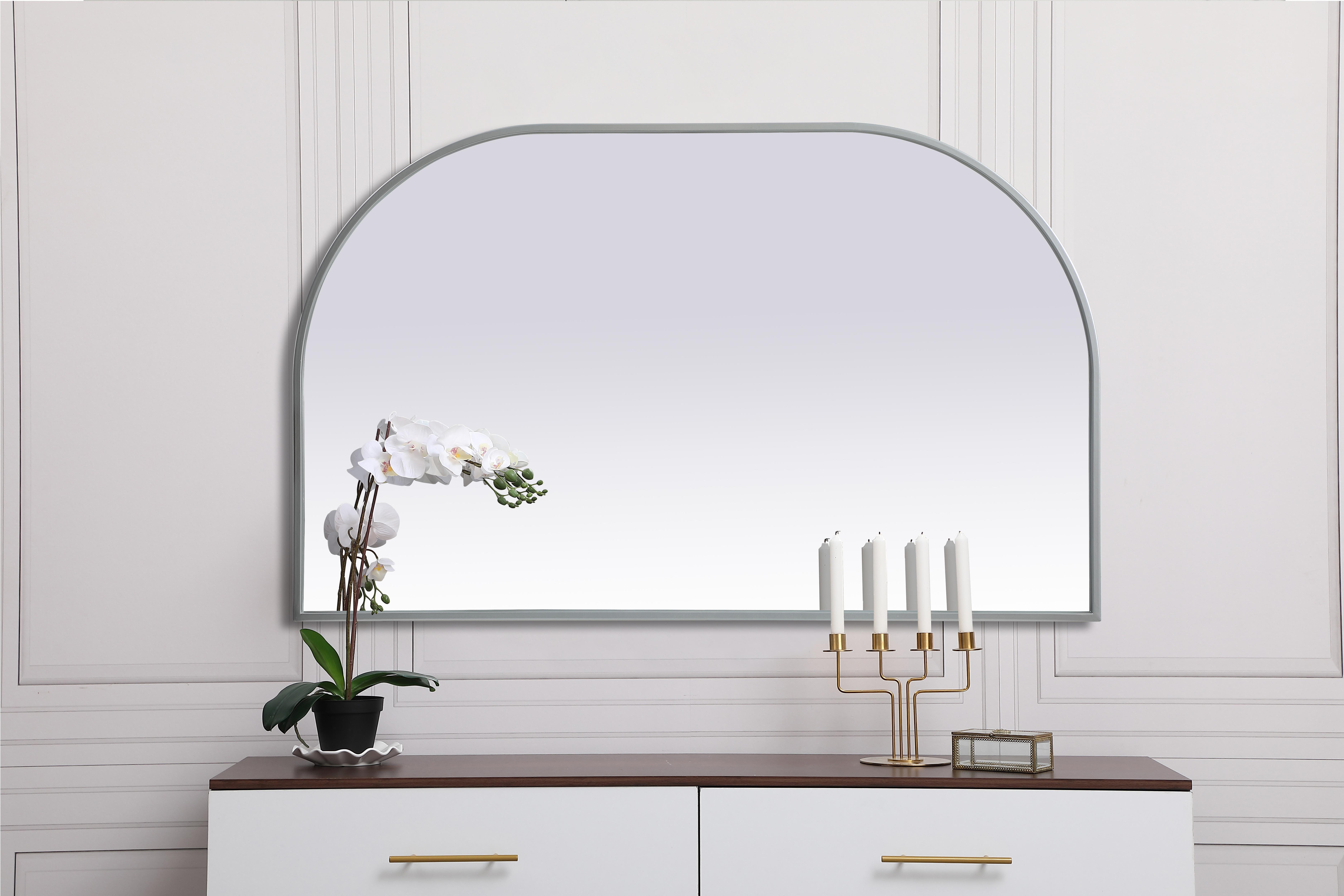 Over the mantel mirror serves an ideal décor on the mantel because it acts as an anchor piece that you can accentuate around with smaller accessories. The reflective qualities of the mirror can also make a space look bigger and brighter since it bounces light coming from your light sources. Designed with square bottom edges and rounded top, this mirror gives an unexpected twist to your typical mirror look. Select from three satin finishes in black, brass, or silver. Collection: Blaire Finish: Silver Width: 39.00" Height: 24.00" Length: 24.00" Weight: 17.00 lb Material: iron and MDF Country of Origin: China Manufacturer Warranty: 1 year limited - alternate view