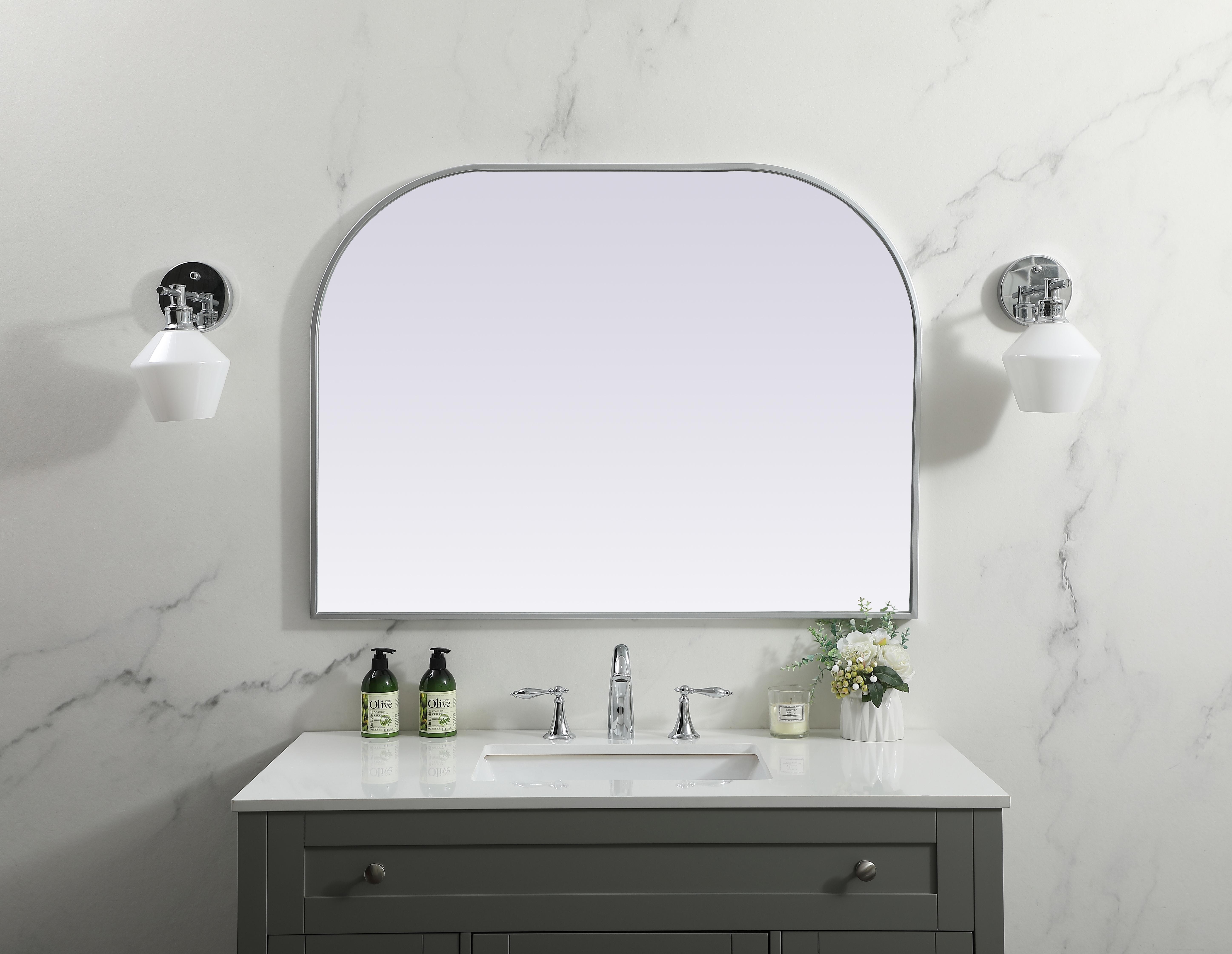 Over the mantel mirror serves an ideal décor on the mantel because it acts as an anchor piece that you can accentuate around with smaller accessories. The reflective qualities of the mirror can also make a space look bigger and brighter since it bounces light coming from your light sources. Designed with square bottom edges and rounded top, this mirror gives an unexpected twist to your typical mirror look. Select from three satin finishes in black, brass, or silver. Collection: Blaire Finish: Silver Width: 40.00" Height: 30.00" Length: 30.00" Weight: 22.00 lb Material: iron and MDF Country of Origin: China Manufacturer Warranty: 1 year limited - alternate view