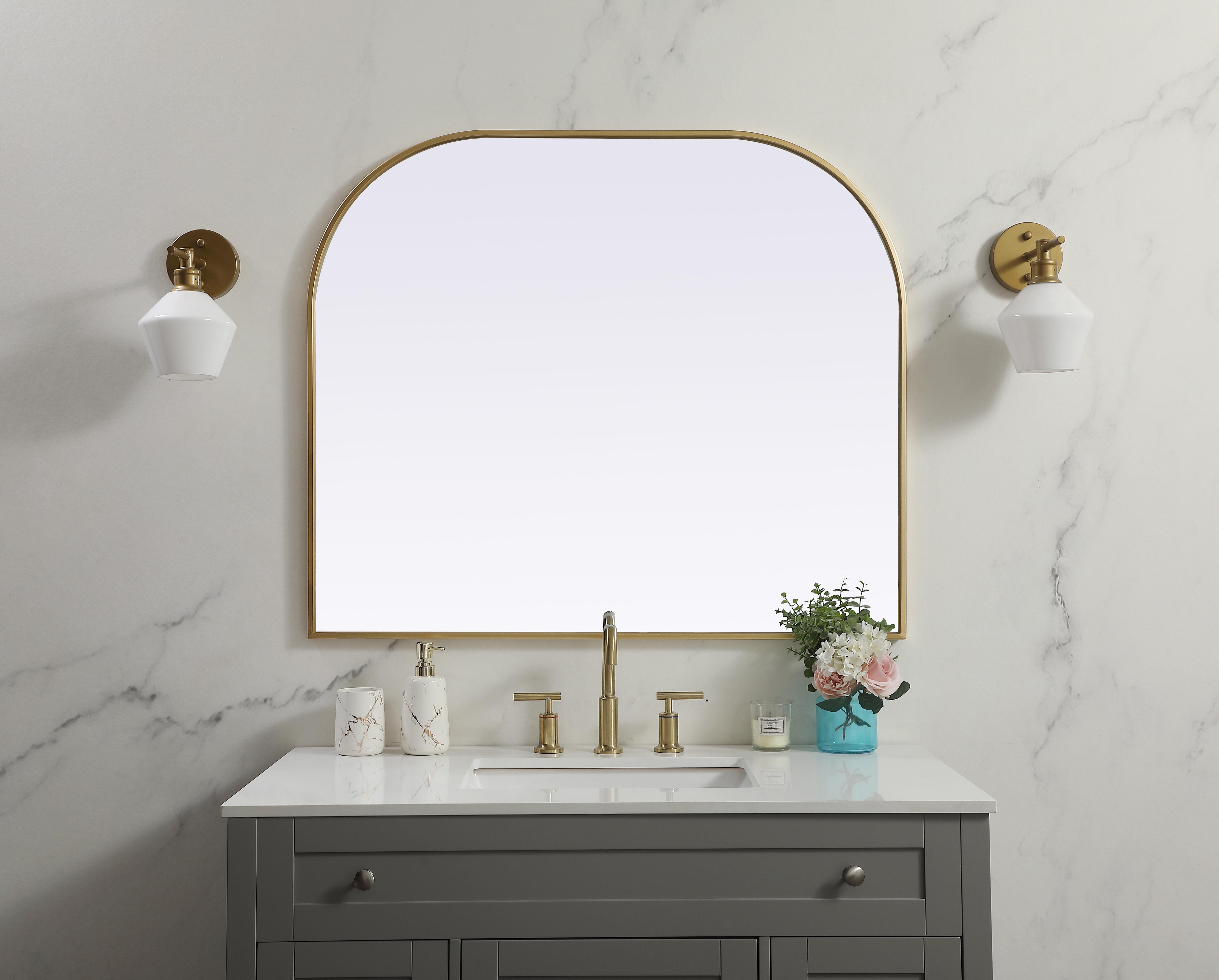 Over the mantel mirror serves an ideal décor on the mantel because it acts as an anchor piece that you can accentuate around with smaller accessories. The reflective qualities of the mirror can also make a space look bigger and brighter since it bounces light coming from your light sources. Designed with square bottom edges and rounded top, this mirror gives an unexpected twist to your typical mirror look. Select from three satin finishes in black, brass, or silver. Collection: Blaire Finish: Brass Width: 40.00" Height: 34.00" Length: 34.00" Weight: 22.00 lb Material: iron and MDF Country of Origin: China Manufacturer Warranty: 1 year limited - alternate view
