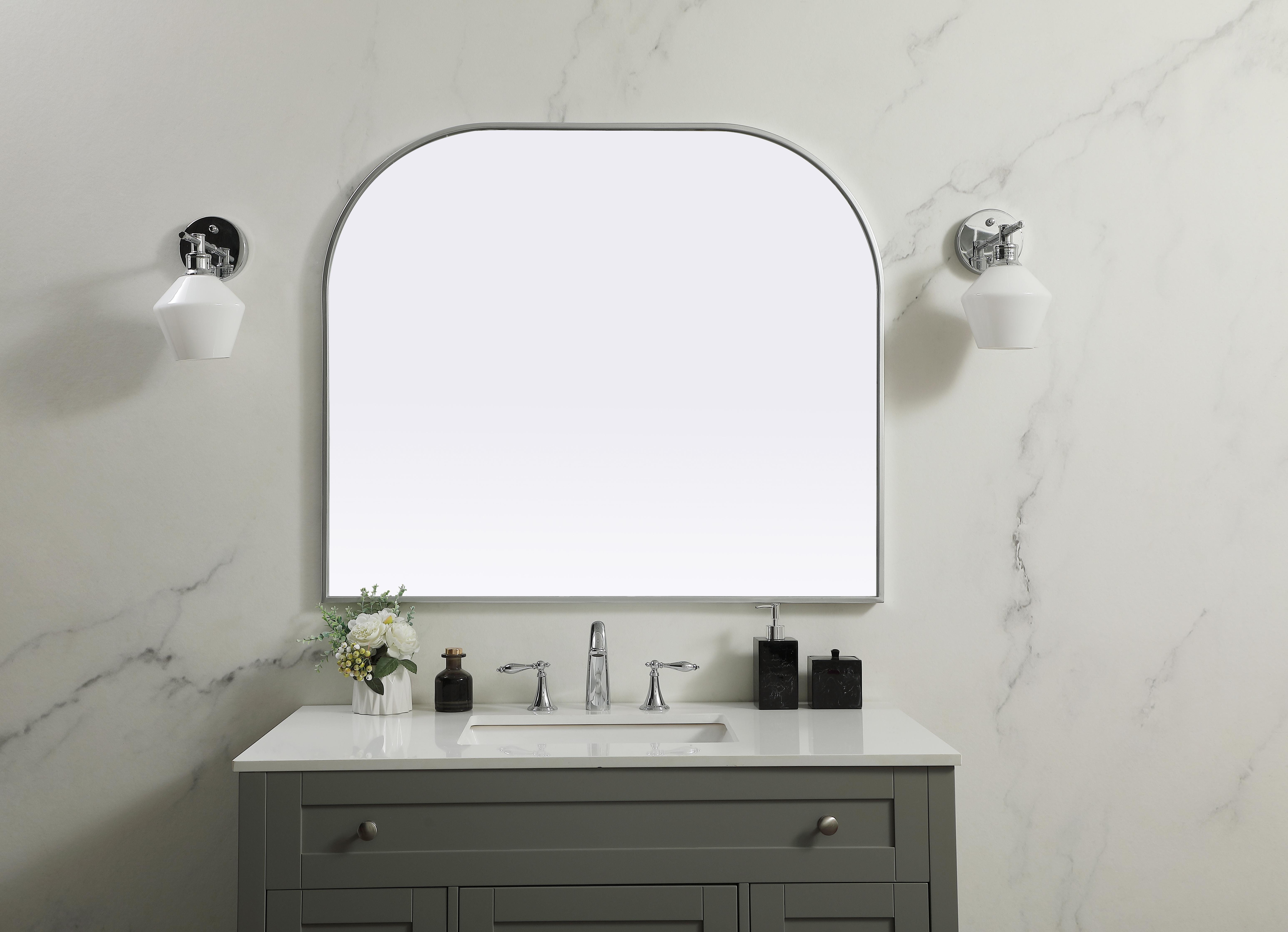 Over the mantel mirror serves an ideal décor on the mantel because it acts as an anchor piece that you can accentuate around with smaller accessories. The reflective qualities of the mirror can also make a space look bigger and brighter since it bounces light coming from your light sources. Designed with square bottom edges and rounded top, this mirror gives an unexpected twist to your typical mirror look. Select from three satin finishes in black, brass, or silver. Collection: Blaire Finish: Silver Width: 40.00" Height: 34.00" Length: 34.00" Weight: 22.00 lb Material: iron and MDF Country of Origin: China Manufacturer Warranty: 1 year limited - alternate view