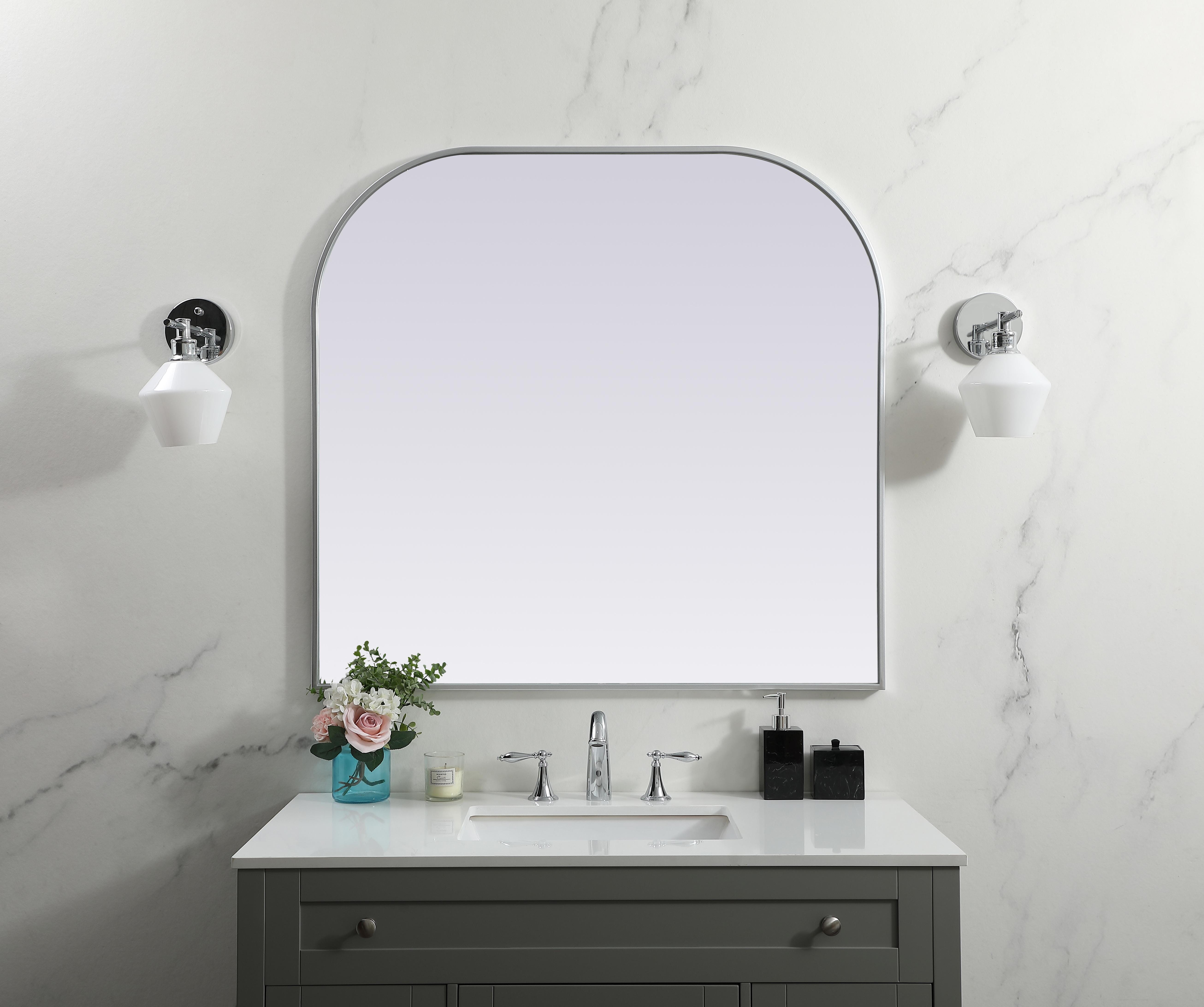 Over the mantel mirror serves an ideal décor on the mantel because it acts as an anchor piece that you can accentuate around with smaller accessories. The reflective qualities of the mirror can also make a space look bigger and brighter since it bounces light coming from your light sources. Designed with square bottom edges and rounded top, this mirror gives an unexpected twist to your typical mirror look. Select from three satin finishes in black, brass, or silver. Collection: Blaire Finish: Silver Width: 40.00" Height: 38.00" Length: 38.00" Weight: 27.00 lb Material: iron and MDF Country of Origin: China Manufacturer Warranty: 1 year limited - alternate view