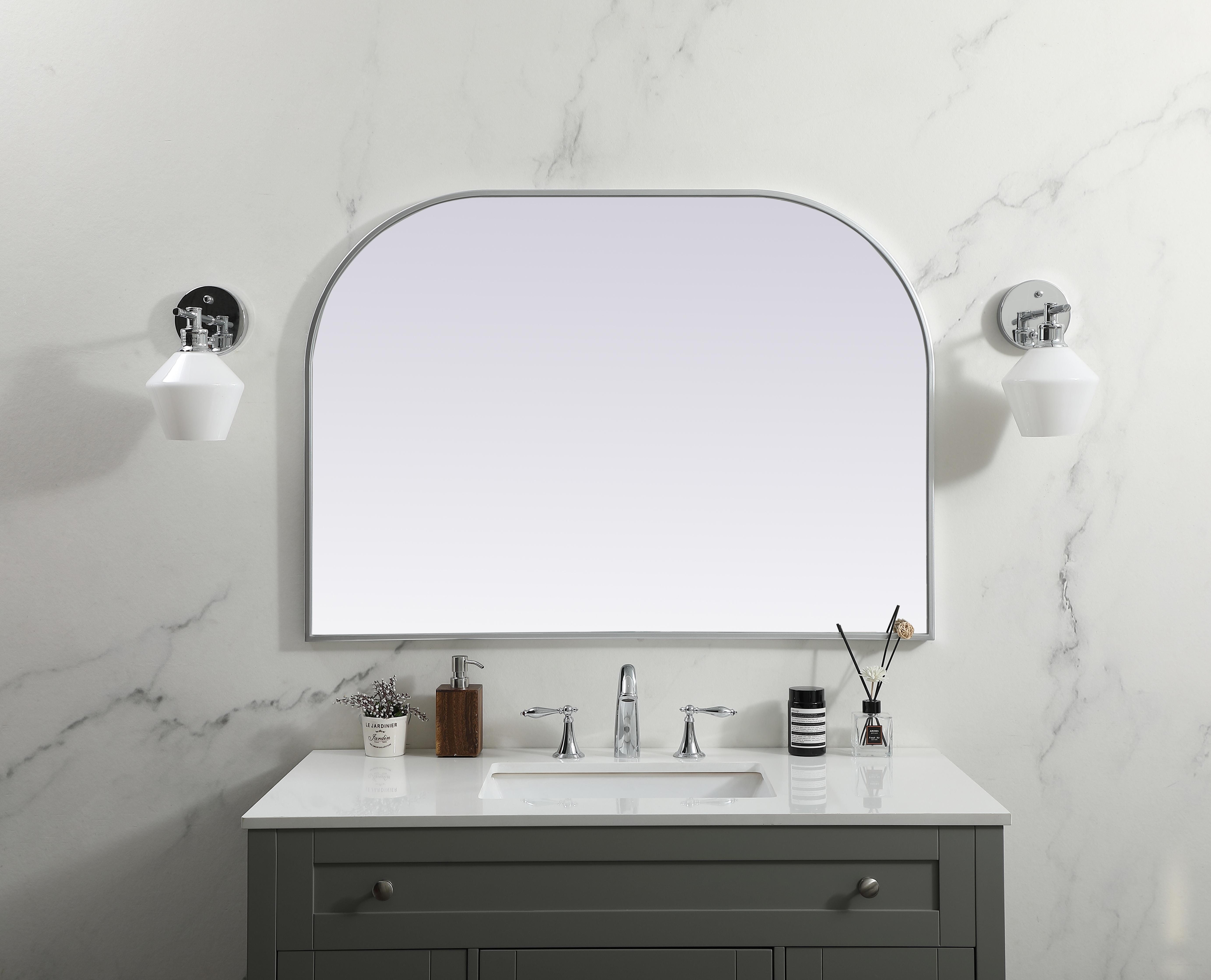 Over the mantel mirror serves an ideal décor on the mantel because it acts as an anchor piece that you can accentuate around with smaller accessories. The reflective qualities of the mirror can also make a space look bigger and brighter since it bounces light coming from your light sources. Designed with square bottom edges and rounded top, this mirror gives an unexpected twist to your typical mirror look. Select from three satin finishes in black, brass, or silver. Collection: Blaire Finish: Silver Width: 42.00" Height: 30.00" Length: 30.00" Weight: 22.00 lb Material: iron and MDF Country of Origin: China Manufacturer Warranty: 1 year limited - alternate view