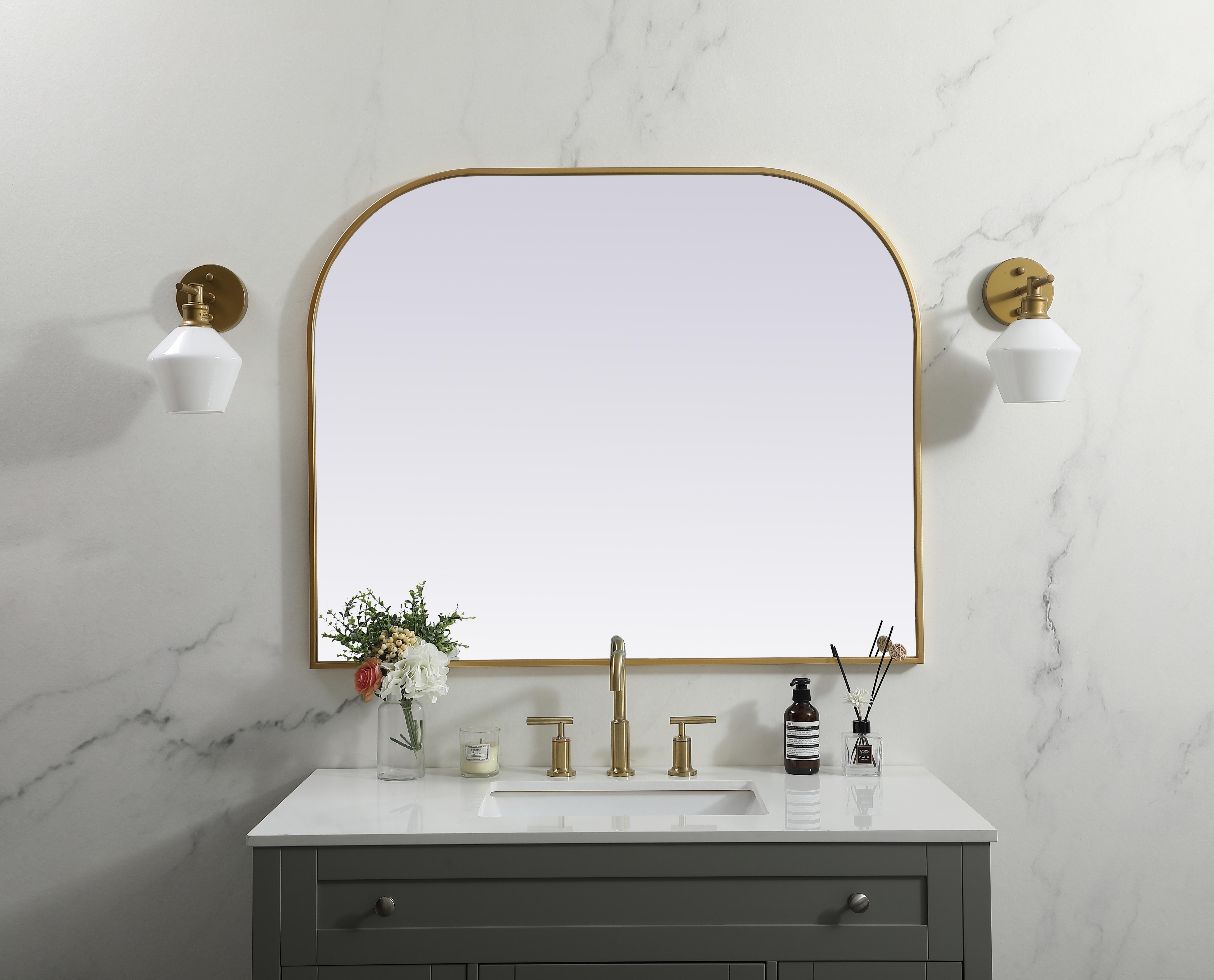 Over the mantel mirror serves an ideal décor on the mantel because it acts as an anchor piece that you can accentuate around with smaller accessories. The reflective qualities of the mirror can also make a space look bigger and brighter since it bounces light coming from your light sources. Designed with square bottom edges and rounded top, this mirror gives an unexpected twist to your typical mirror look. Select from three satin finishes in black, brass, or silver. Collection: Blaire Finish: Brass Width: 42.00" Height: 34.00" Length: 34.00" Weight: 26.00 lb Material: iron and MDF Country of Origin: China Manufacturer Warranty: 1 year limited - alternate view