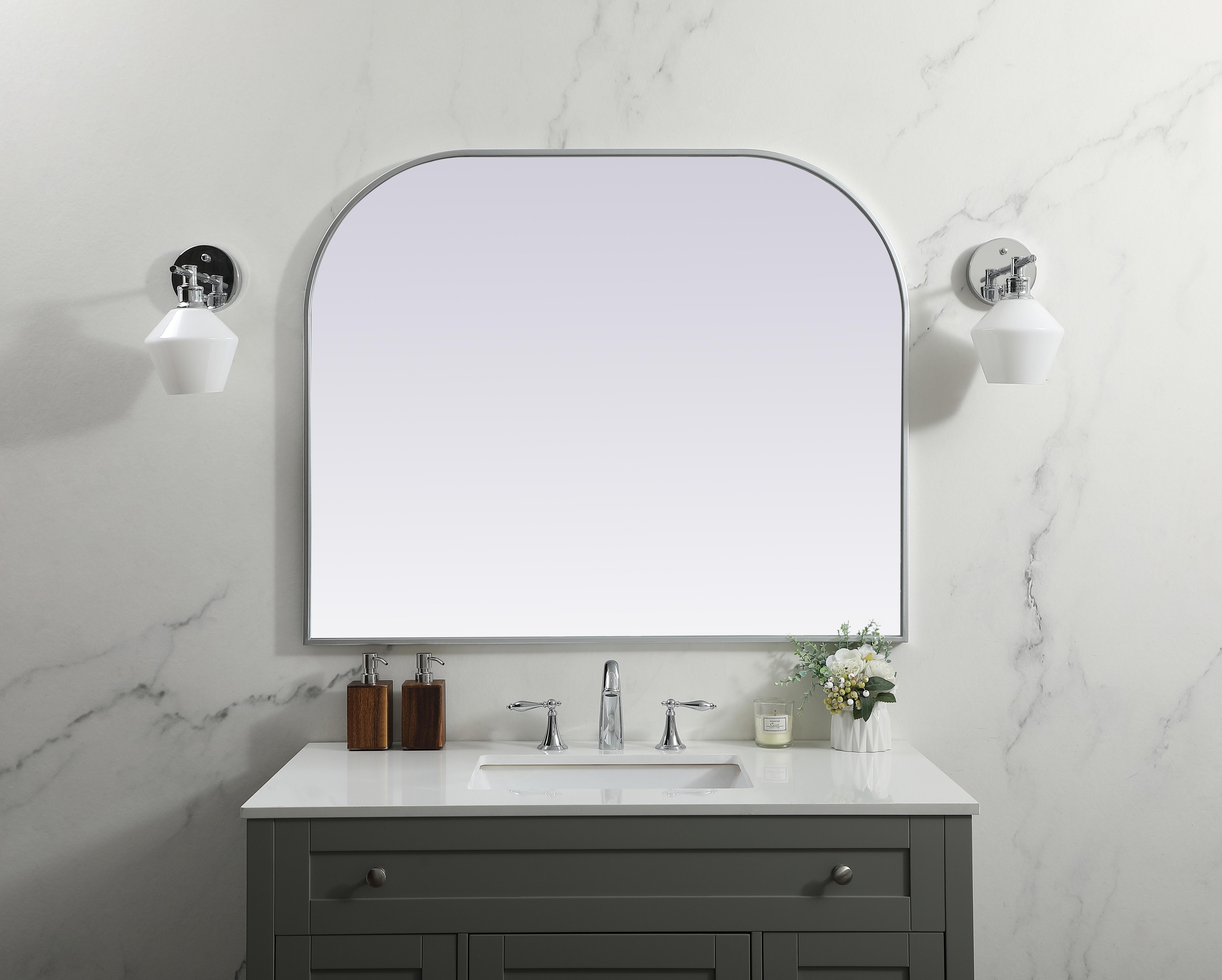 Over the mantel mirror serves an ideal décor on the mantel because it acts as an anchor piece that you can accentuate around with smaller accessories. The reflective qualities of the mirror can also make a space look bigger and brighter since it bounces light coming from your light sources. Designed with square bottom edges and rounded top, this mirror gives an unexpected twist to your typical mirror look. Select from three satin finishes in black, brass, or silver. Collection: Blaire Finish: Silver Width: 42.00" Height: 34.00" Length: 34.00" Weight: 26.00 lb Material: iron and MDF Country of Origin: China Manufacturer Warranty: 1 year limited - alternate view