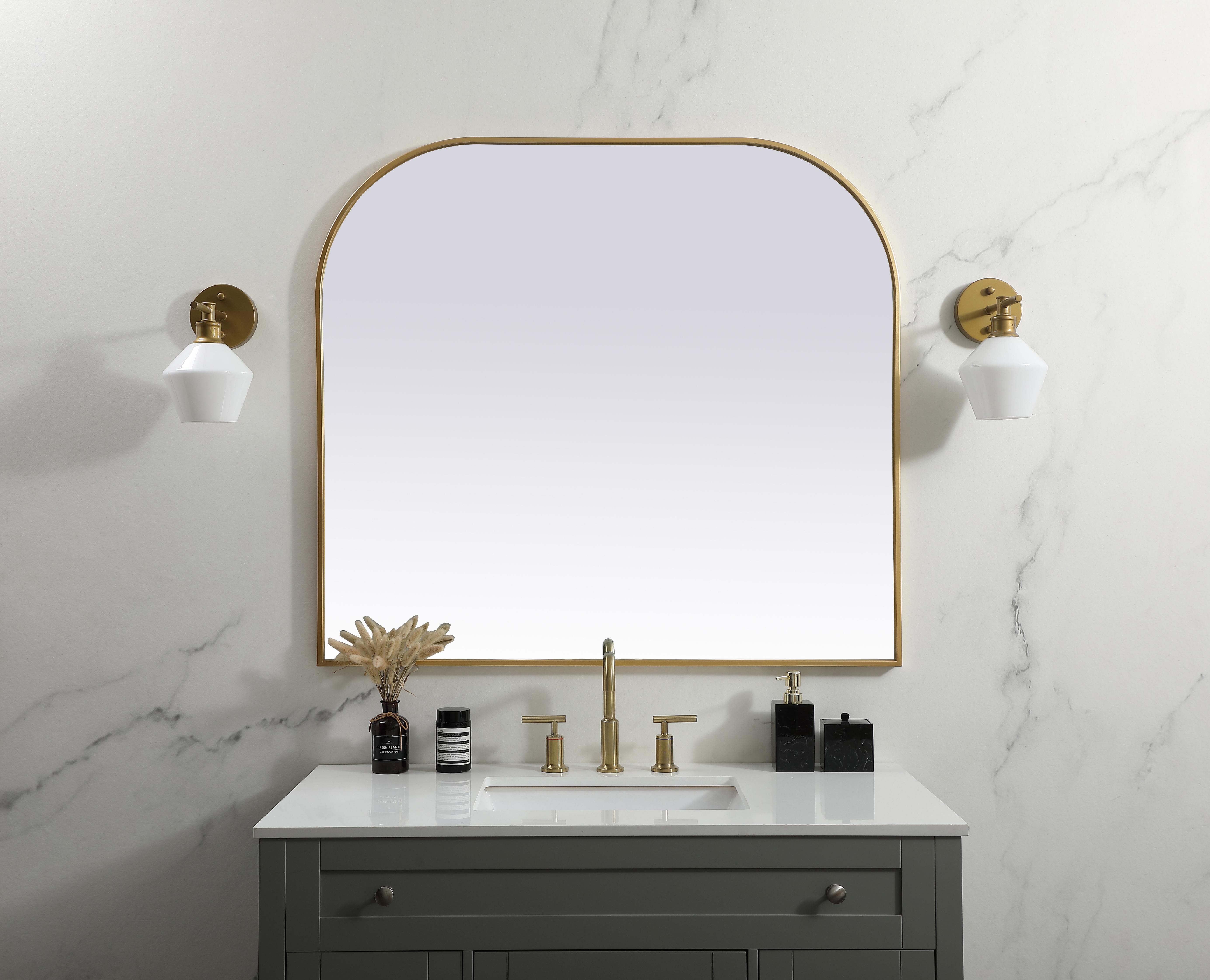 Over the mantel mirror serves an ideal décor on the mantel because it acts as an anchor piece that you can accentuate around with smaller accessories. The reflective qualities of the mirror can also make a space look bigger and brighter since it bounces light coming from your light sources. Designed with square bottom edges and rounded top, this mirror gives an unexpected twist to your typical mirror look. Select from three satin finishes in black, brass, or silver. Collection: Blaire Finish: Brass Width: 42.00" Height: 38.00" Length: 38.00" Weight: 28.00 lb Material: iron and MDF Country of Origin: China Manufacturer Warranty: 1 year limited - alternate view