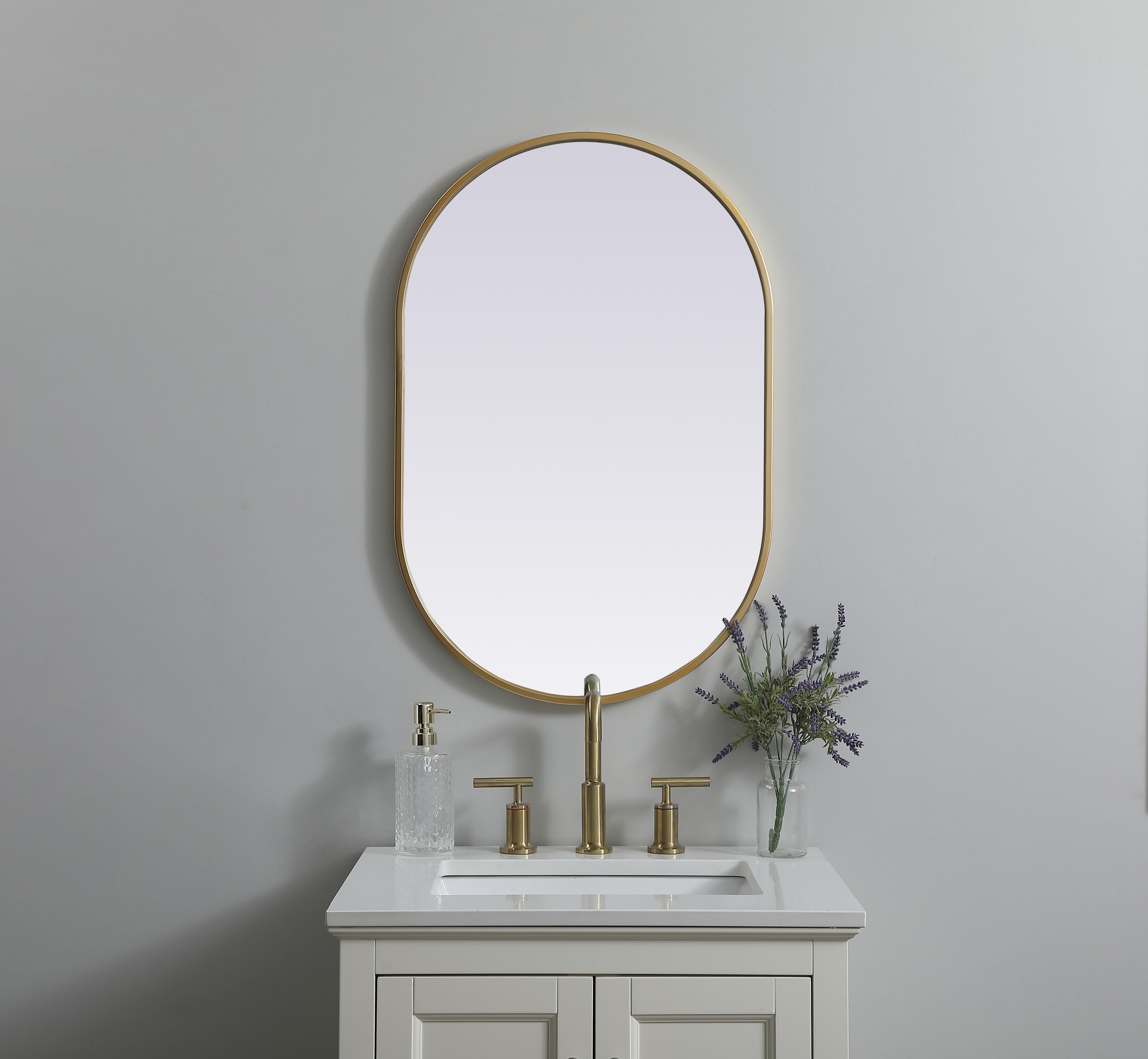 Instantly open up any space in your home with this minimalist wall-mounted mirror. Crafted of metal, this mirror strikes a pill-shaped silhouette. Its slender, clean-lined frame sports a classic finish, while the glass mirror within features a flat, for a brilliant reflection, letting the light bounce off to expand your space. Designed in a pill shape, this metal-frame mirror showcases in the three available satin finishes in black, brass, or silver. Mount this work of art in any room of your choice for added visual impact. Collection: Asha Finish: Brass Width: 20.00" Height: 30.00" Length: 30.00" Weight: 11.00 lb Material: iron and MDF Country of Origin: China Manufacturer Warranty: 1 year limited - alternate view