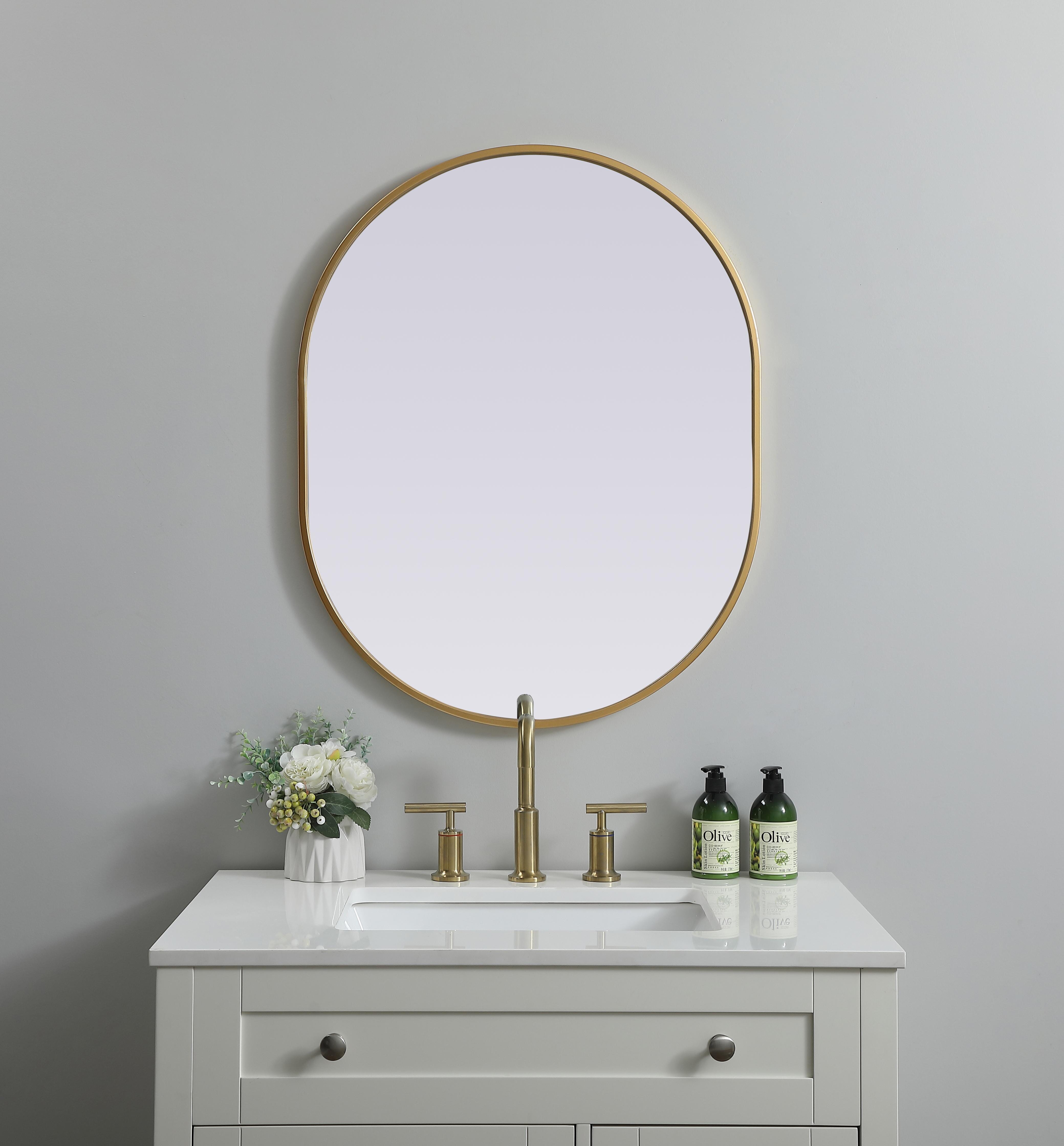 Instantly open up any space in your home with this minimalist wall-mounted mirror. Crafted of metal, this mirror strikes a pill-shaped silhouette. Its slender, clean-lined frame sports a classic finish, while the glass mirror within features a flat, for a brilliant reflection, letting the light bounce off to expand your space. Designed in a pill shape, this metal-frame mirror showcases in the three available satin finishes in black, brass, or silver. Mount this work of art in any room of your choice for added visual impact. Collection: Asha Finish: Brass Width: 24.00" Height: 30.00" Length: 30.00" Weight: 12.00 lb Material: iron and MDF Country of Origin: China Manufacturer Warranty: 1 year limited - alternate view